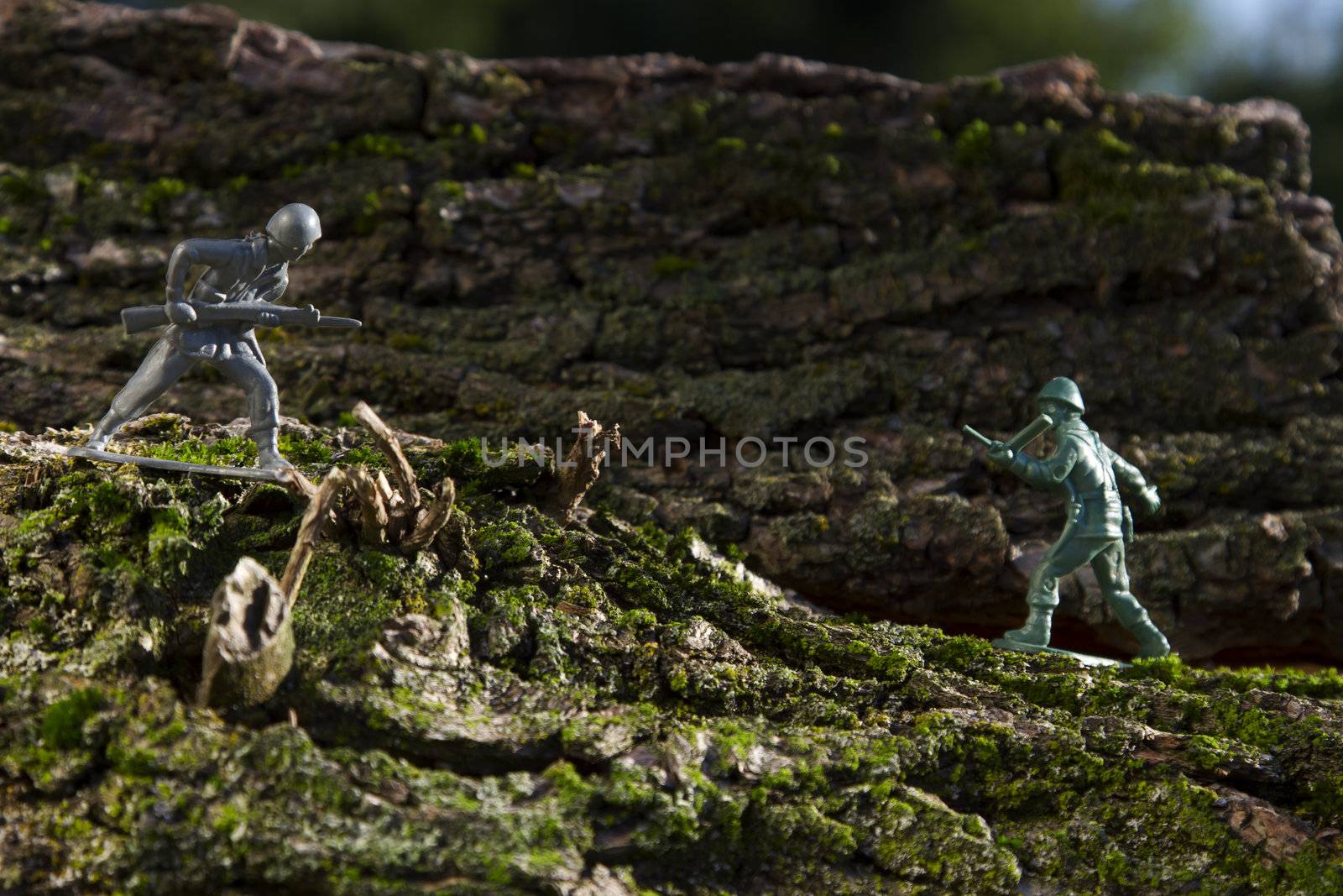 a grey and green plastic toy soldier in the middle of a battle on top of wood