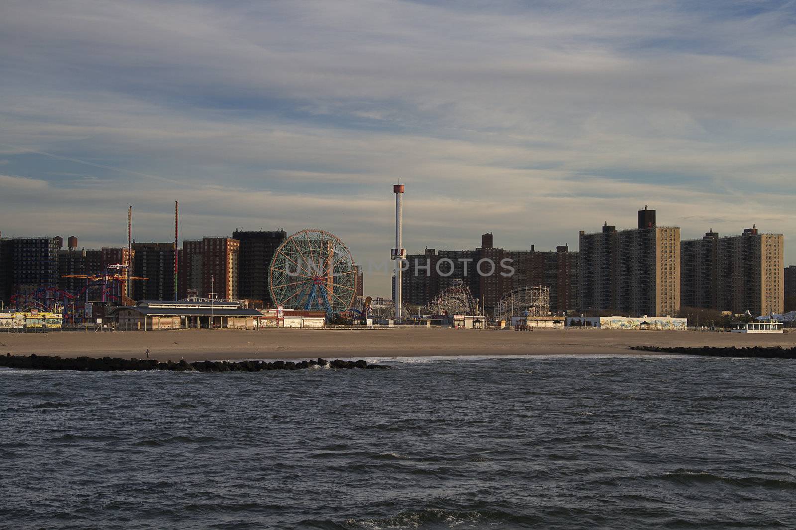 Coney Island beach at sunrise with building in the background and ocean in the foreground