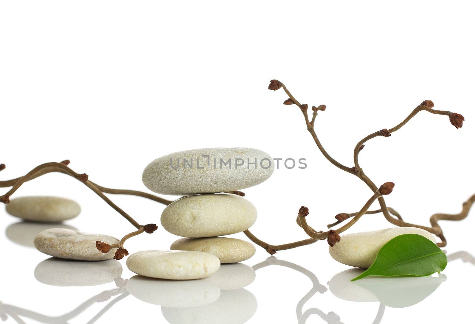 Spa stones and green leaf, isolated on white background.