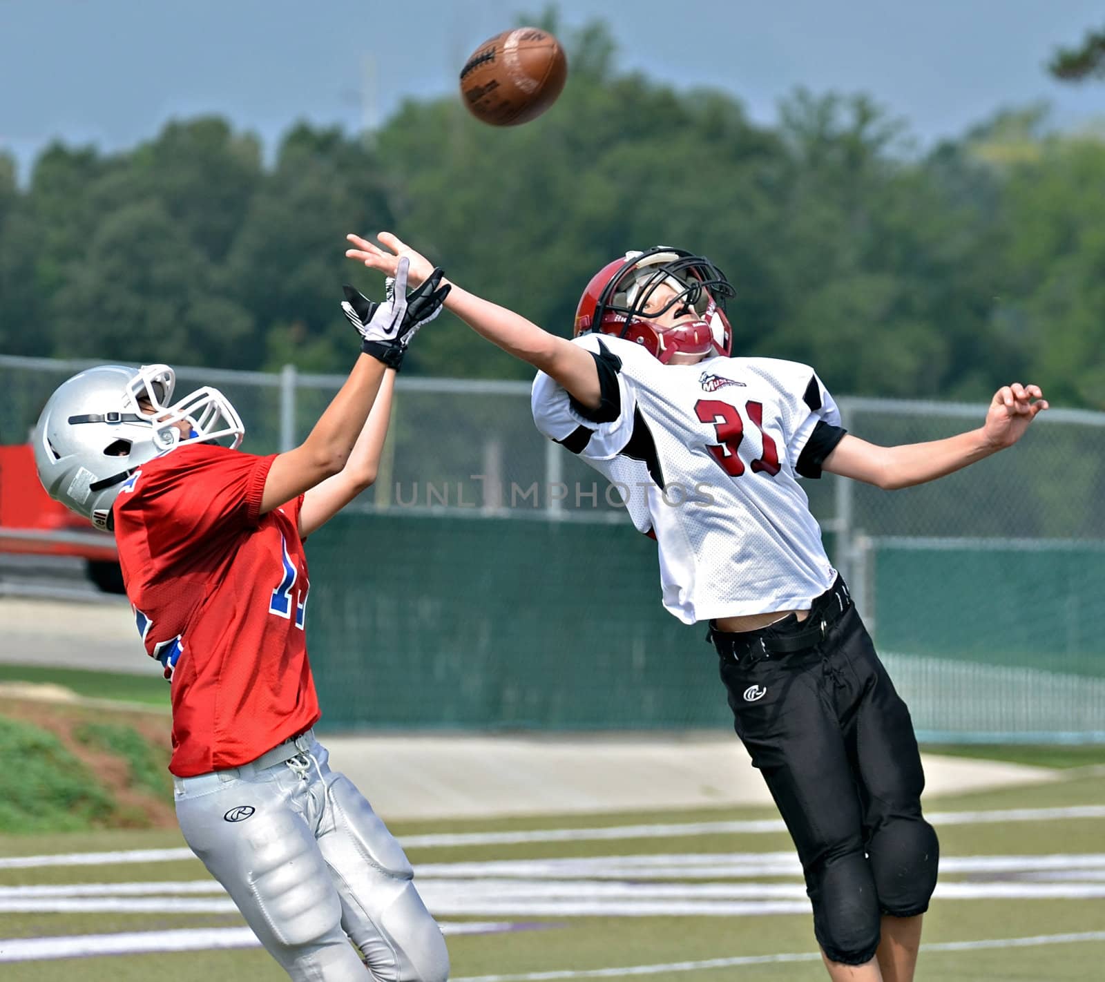 CUMMING, GA/USA - SEPTEMBER 8: Unidentified boys fighting for the pass at the goal line. A team of 7th grade boys September 9, 2012 in Cumming GA. The Wildcats  vs The Mustangs.