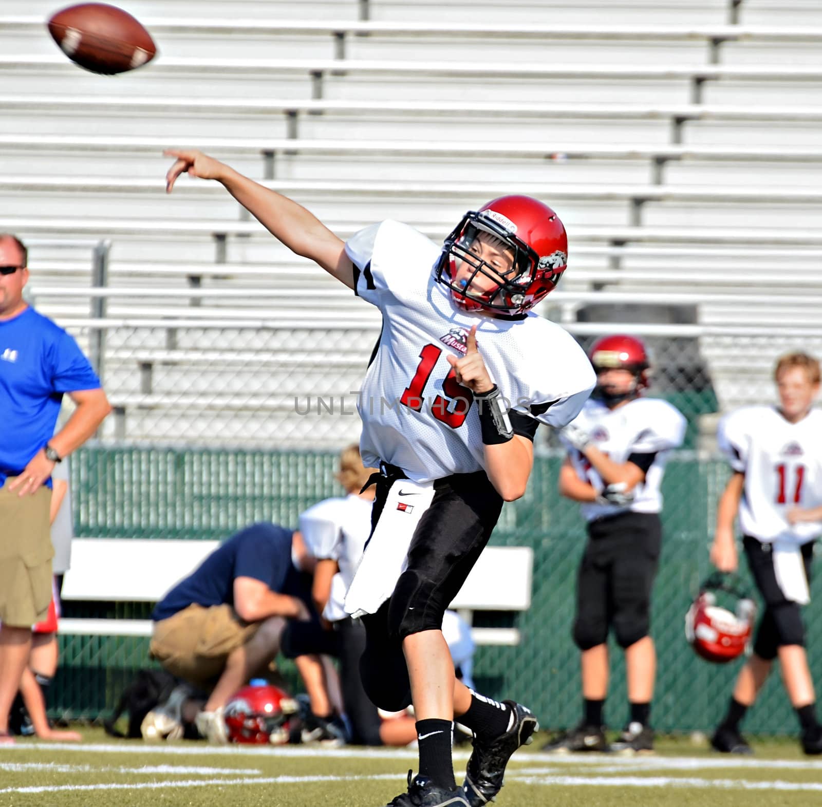 CUMMING, GA/USA - SEPTEMBER 8: Unidentified boy throwing a pass during a football game. A team of 7th grade boys September 8, 2012 in Cumming GA. The Wildcats  vs The Mustangs.
