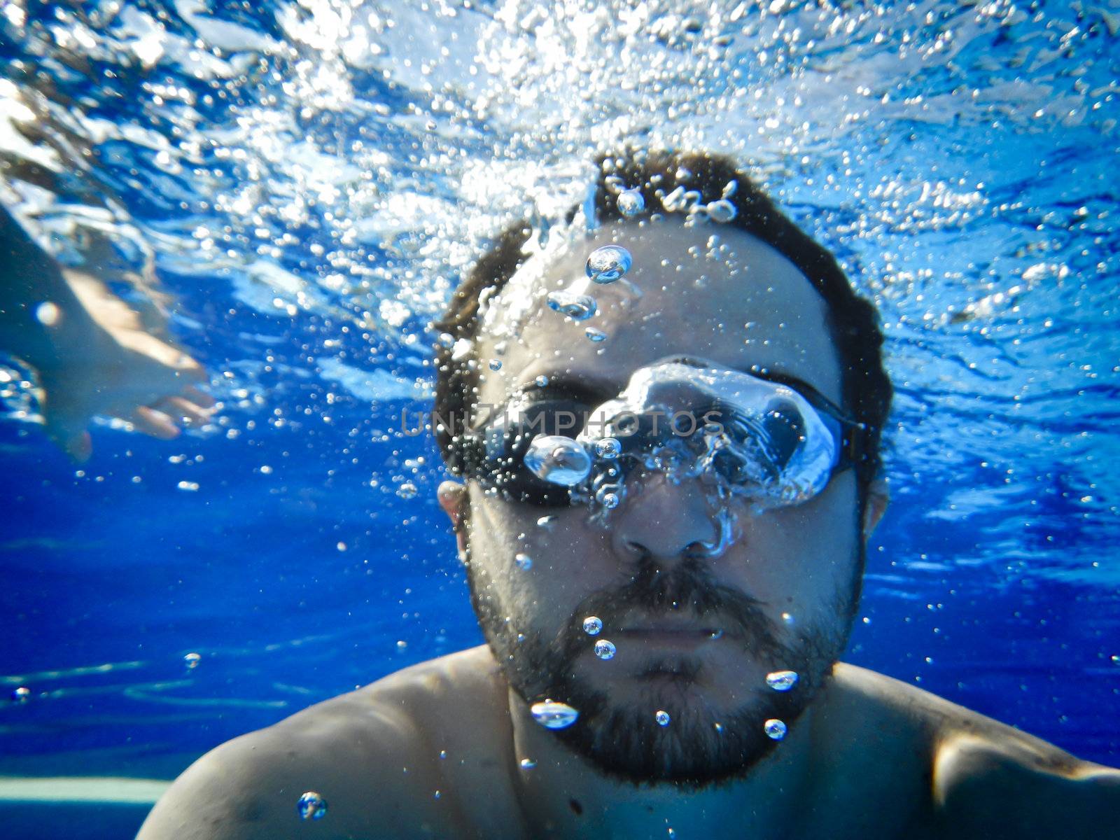 Man swimming underwater in the pool