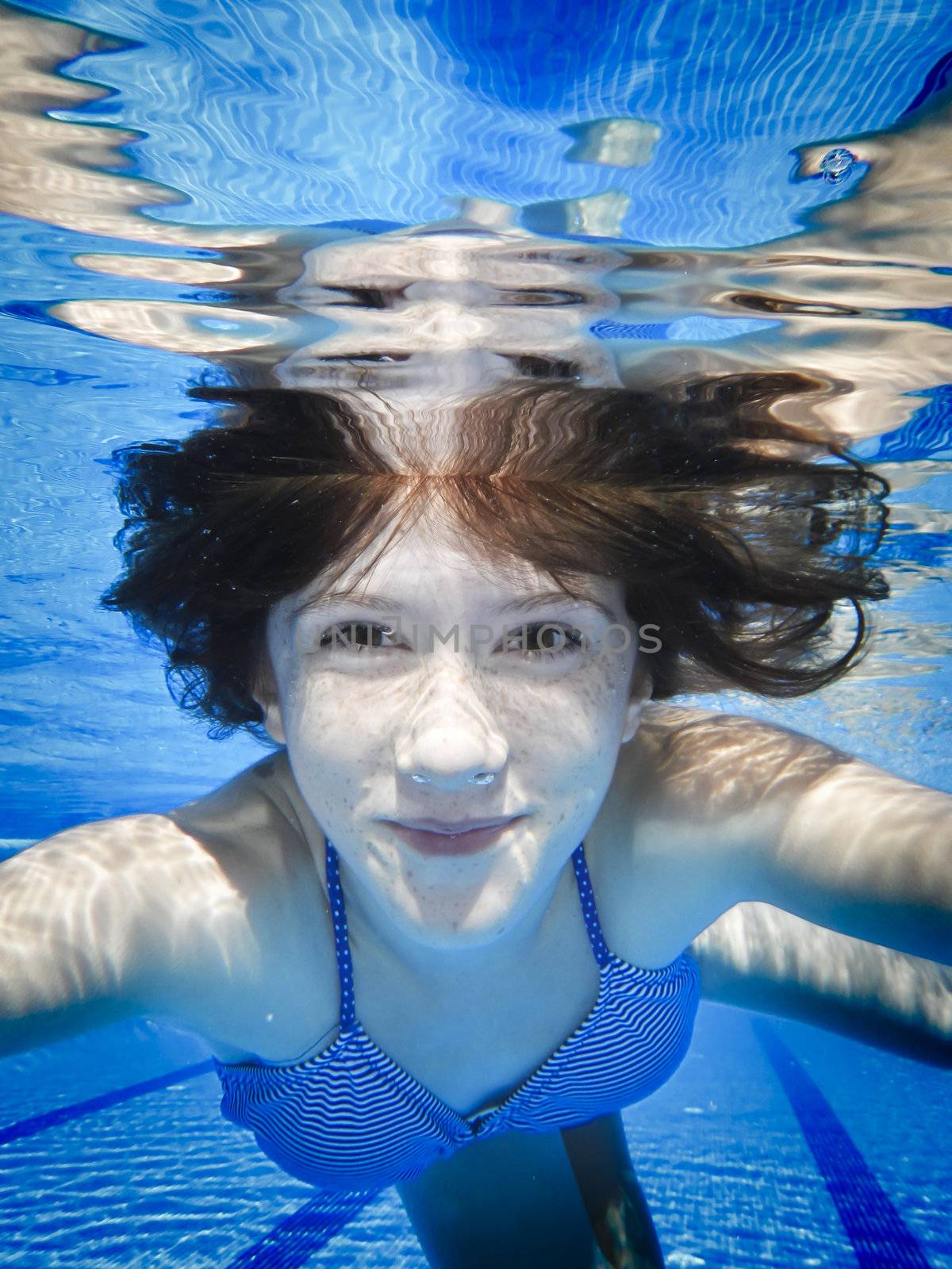 Teenage swimming underwater in the pool