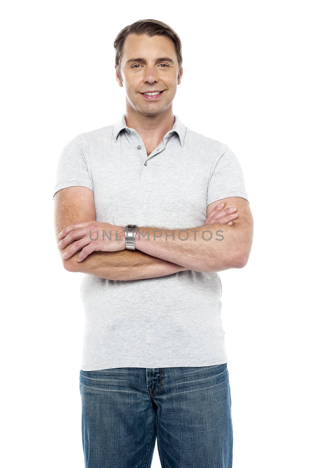 Joyous young man posing with his arms crossed isolated over white background