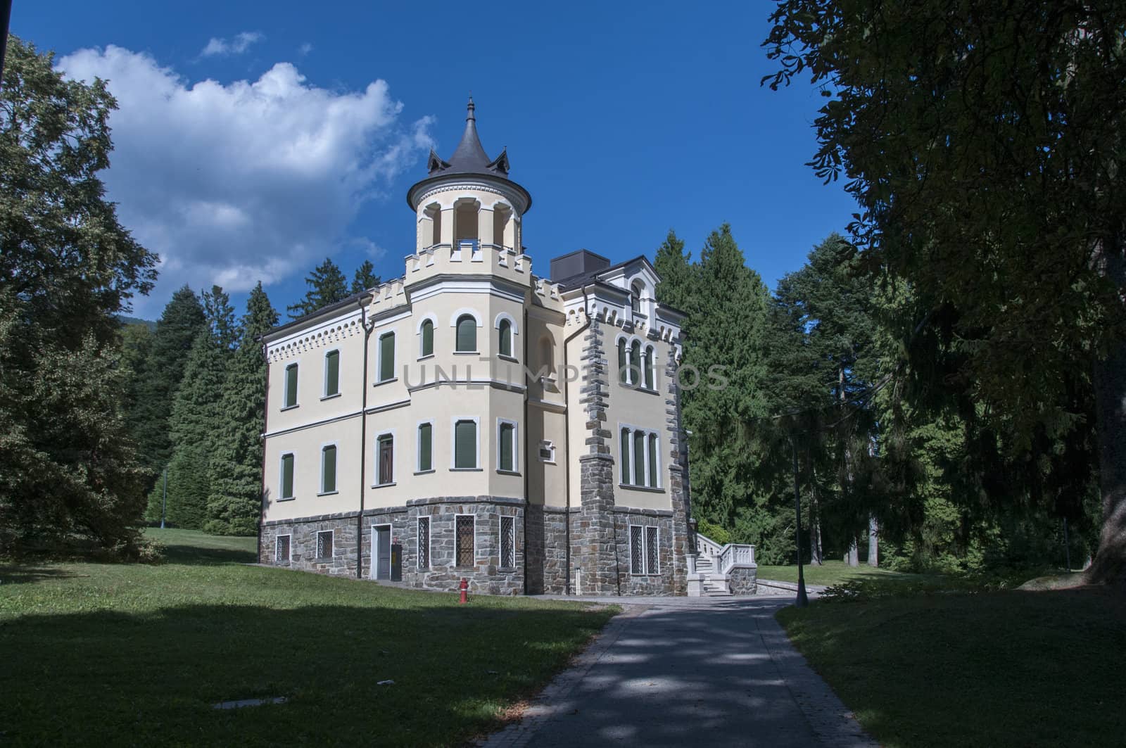 big building in Italy in the place Levico Terme with green trees and grass around