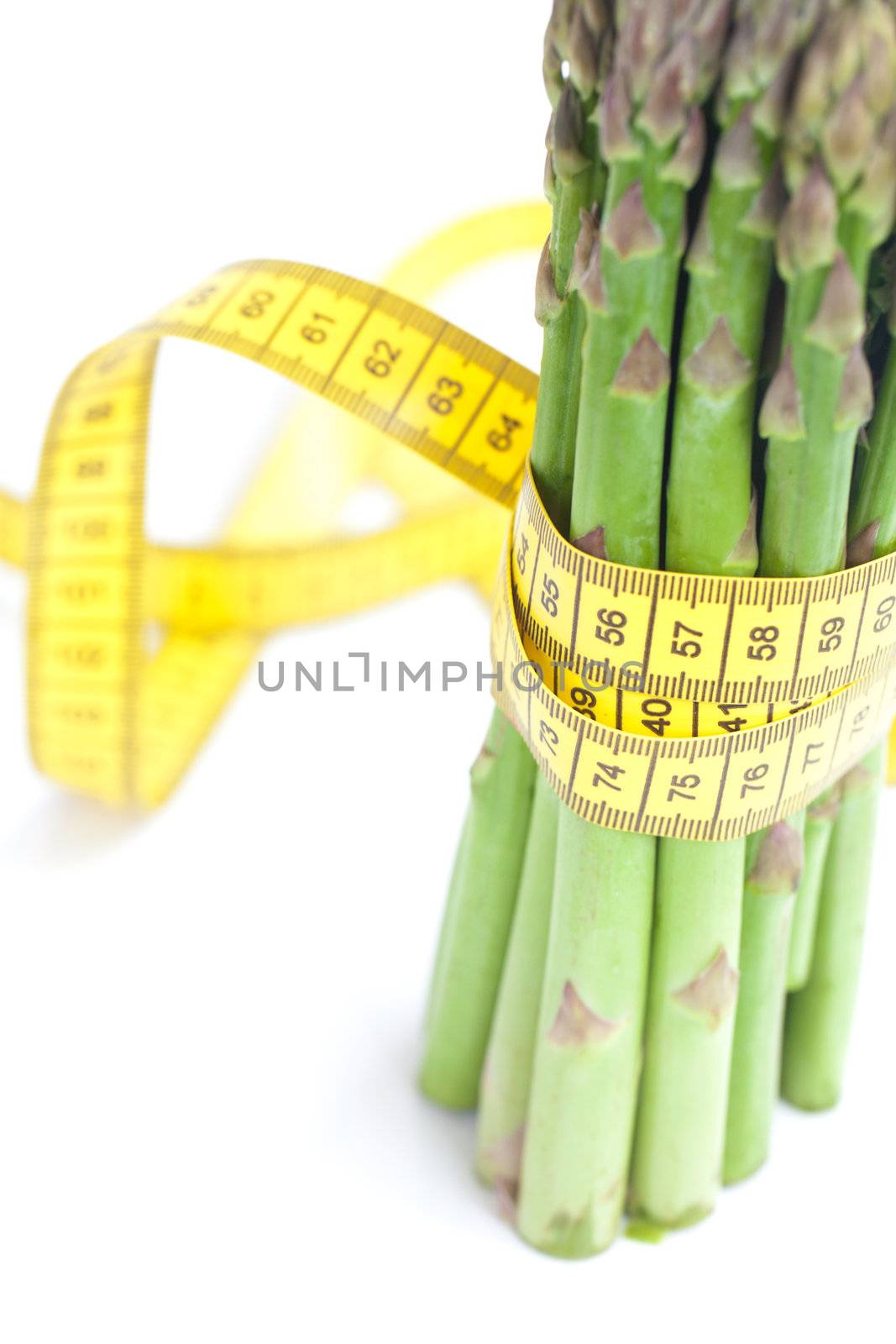bunch of asparagus tied with measuring tape isolated on white