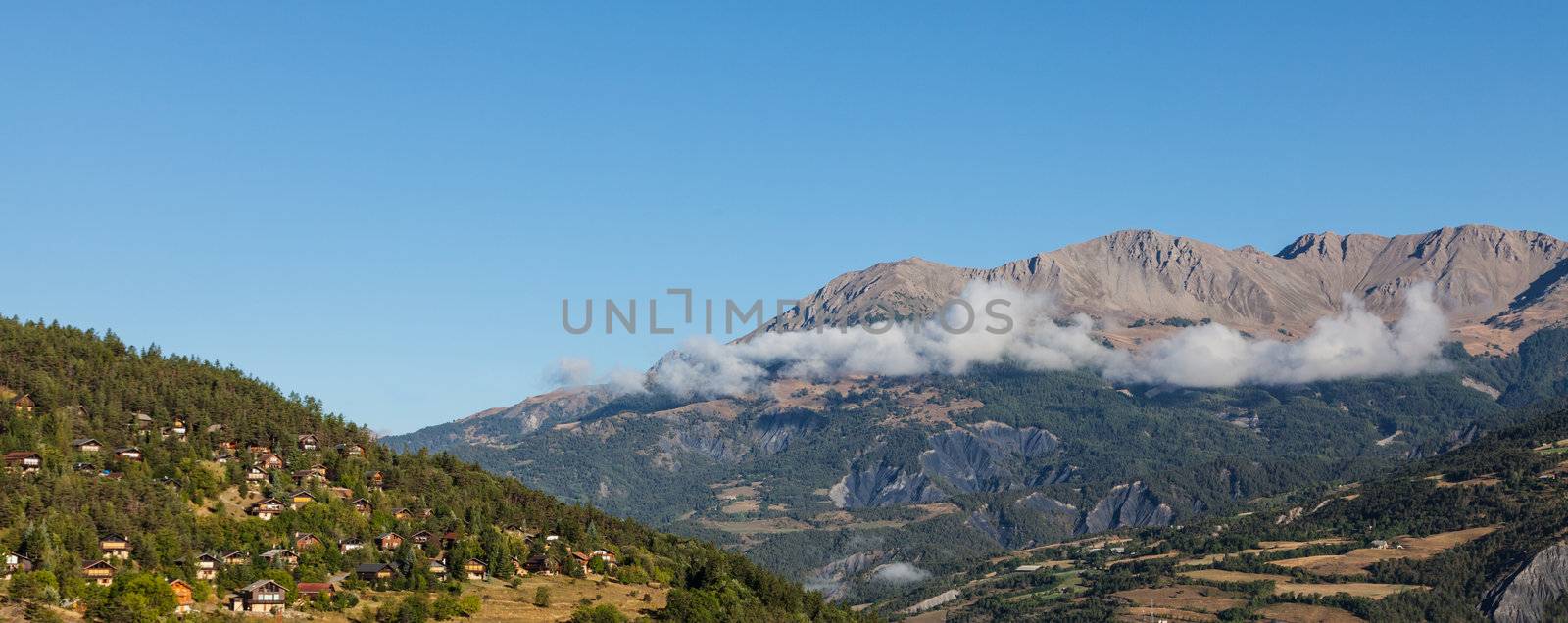 Image of a village located on a high altitude slope with forest in The Southern French Alps in Alpes-de-Haute-Provence region.