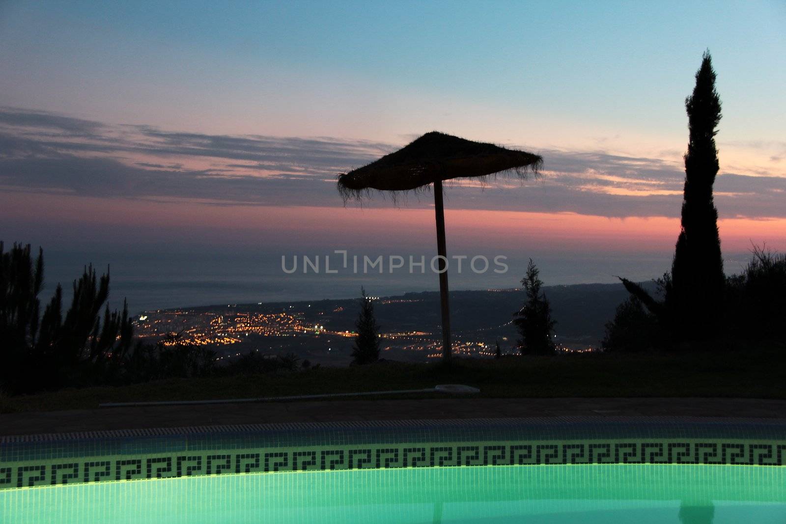 Tranquil scene with straw umbrella and nice sunset