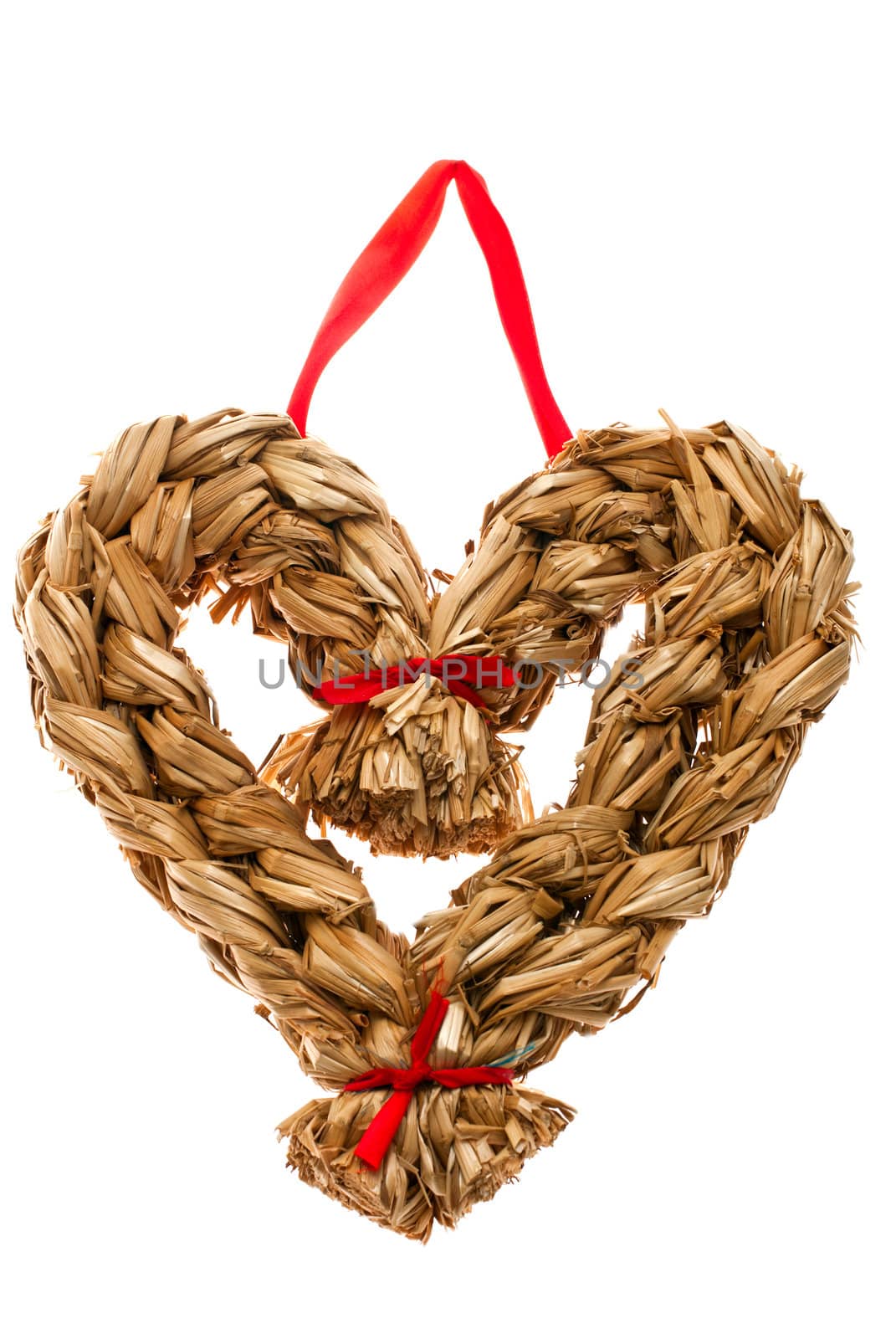 Christmas decoration hand made from straw in shape of heart isolated on white