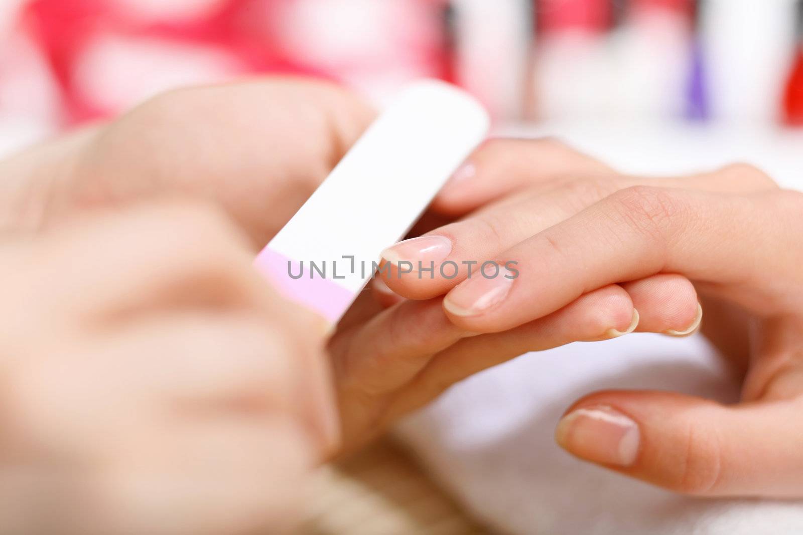 Young woman is getting manicure in a beauty salon