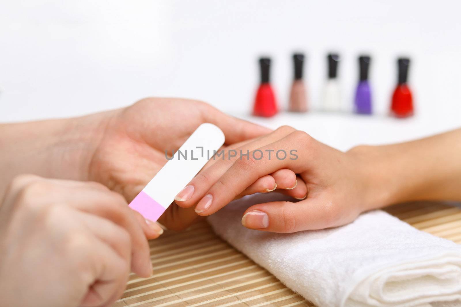 Young woman is getting manicure in a beauty salon