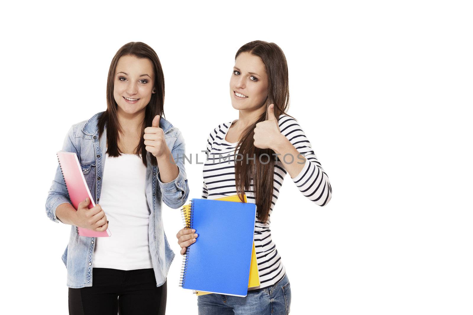 two female students with exercising books showing thumbs up on white background
