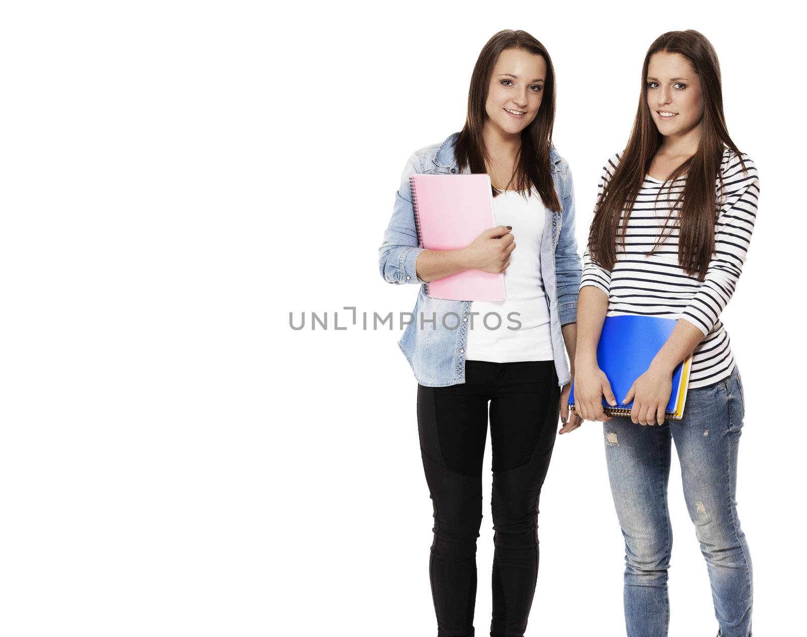 portrait of two pretty student teenagers with note pads on white background