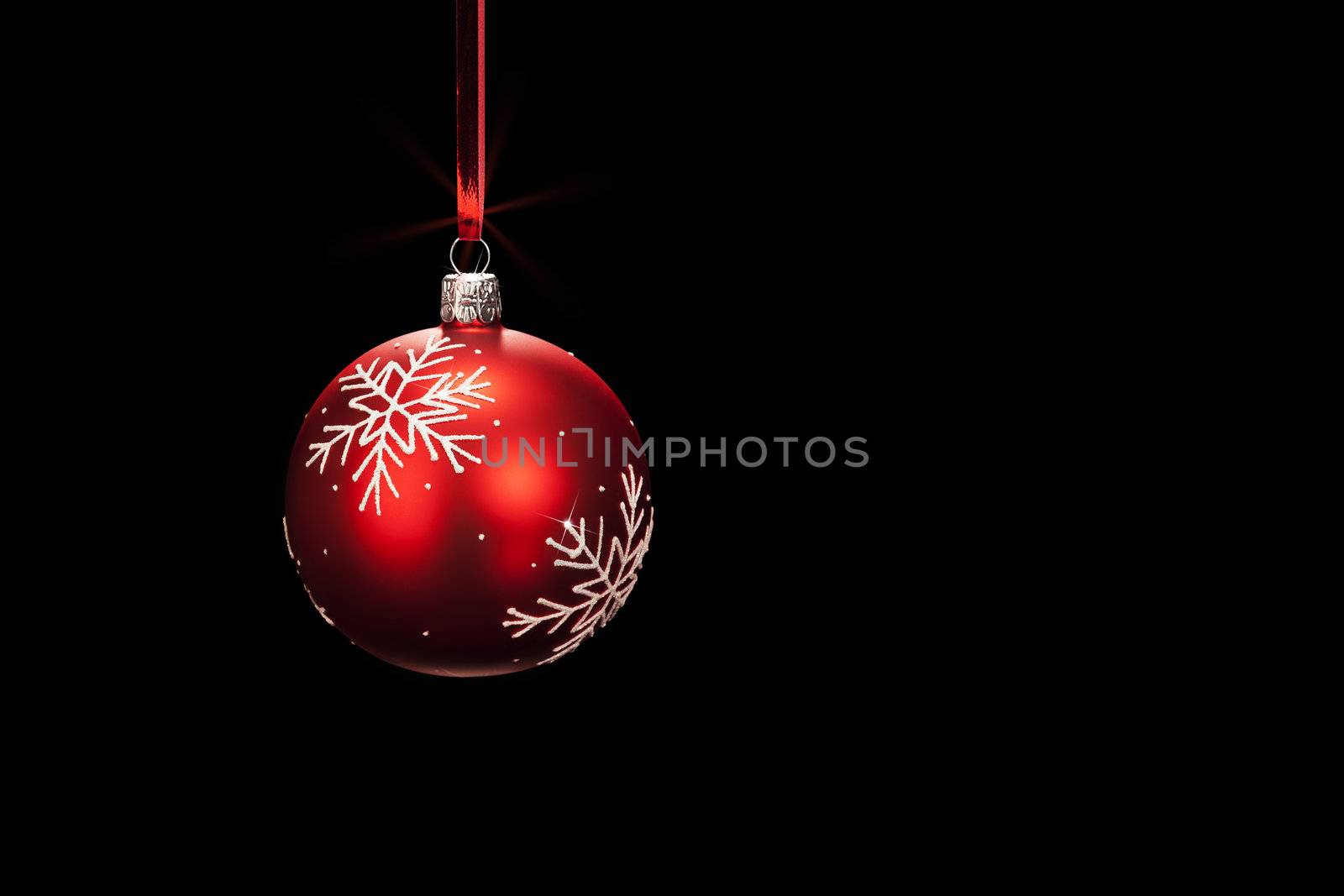 hanging red dull christmas ball on black background