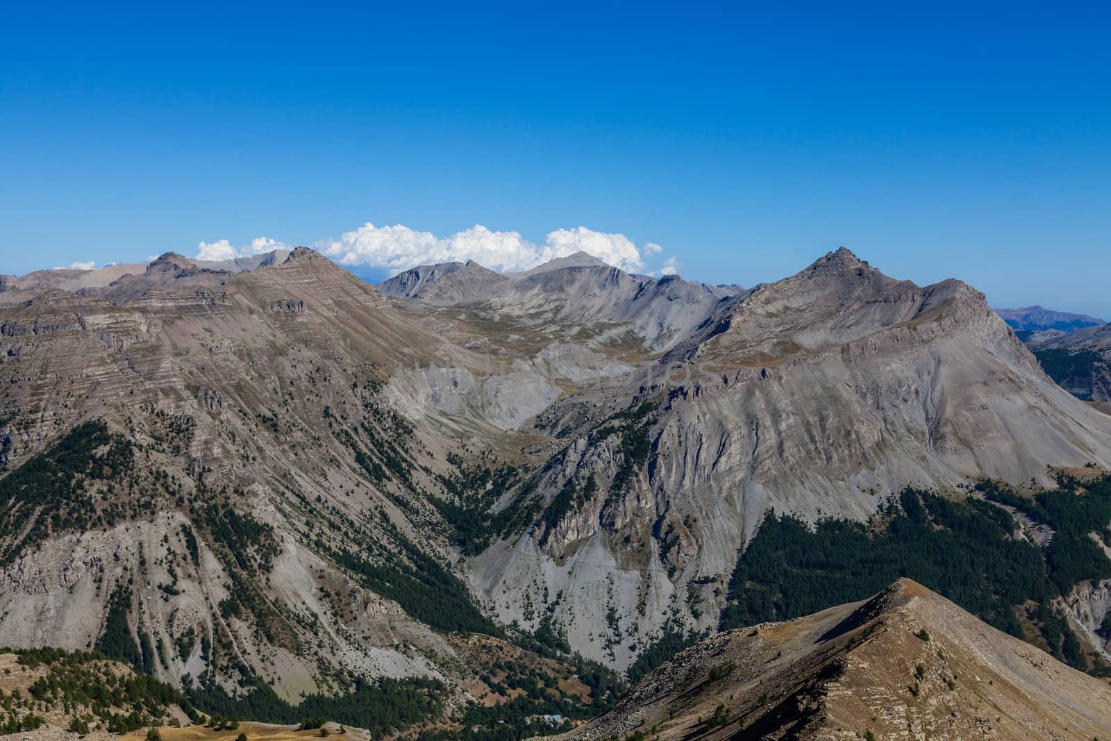 Impressive high altitude landscape located in The Southern French Alps. You can see Roche Grande (2752m) with Chateauvieux Valley in the right part,De Gorgias peaks in the left part and down is the  green valley of  l'Estrop.The point of view is on the Mountain Pass Lausson.