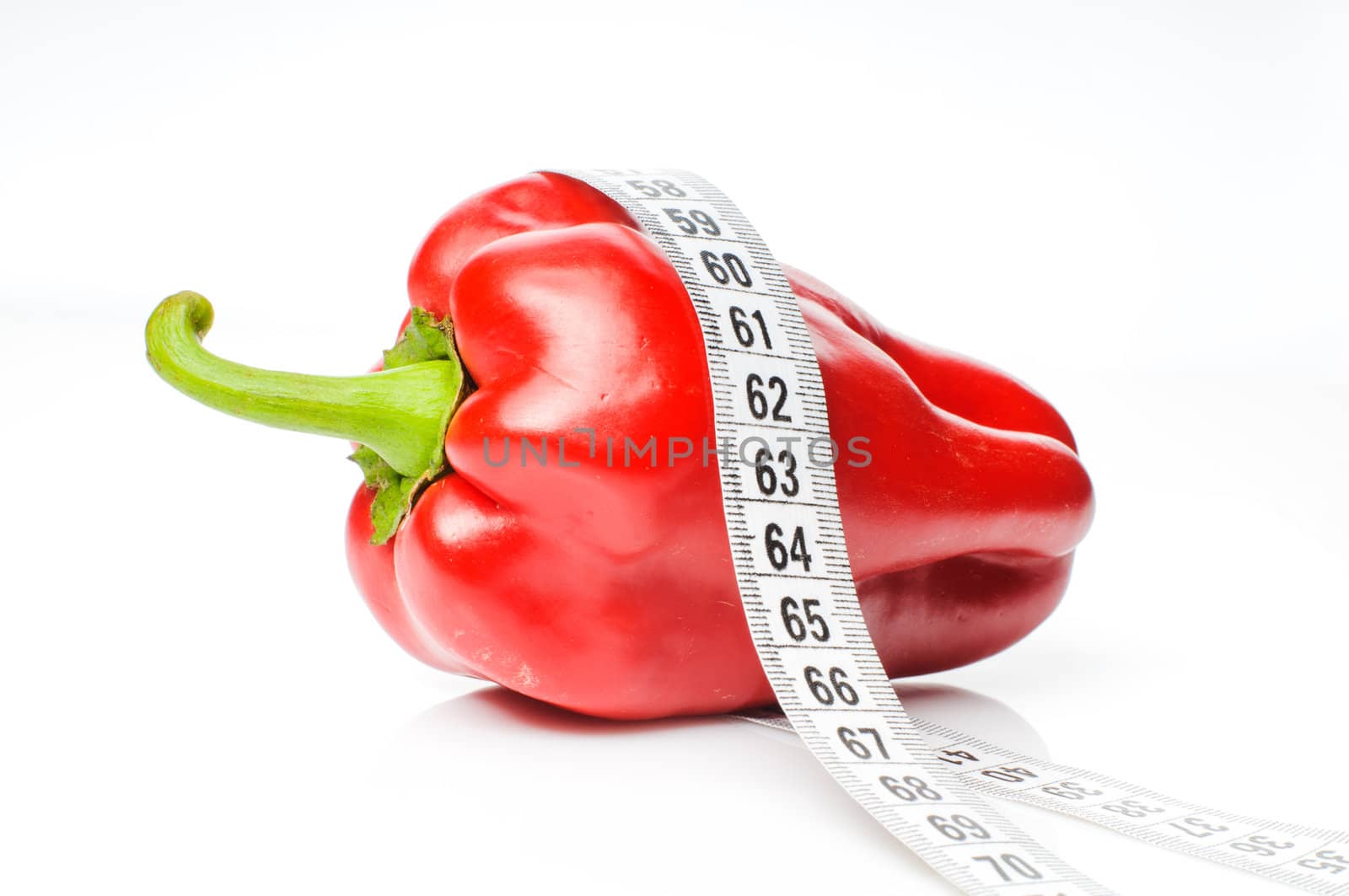 Red sweet pepper in measure tape isolated on white background