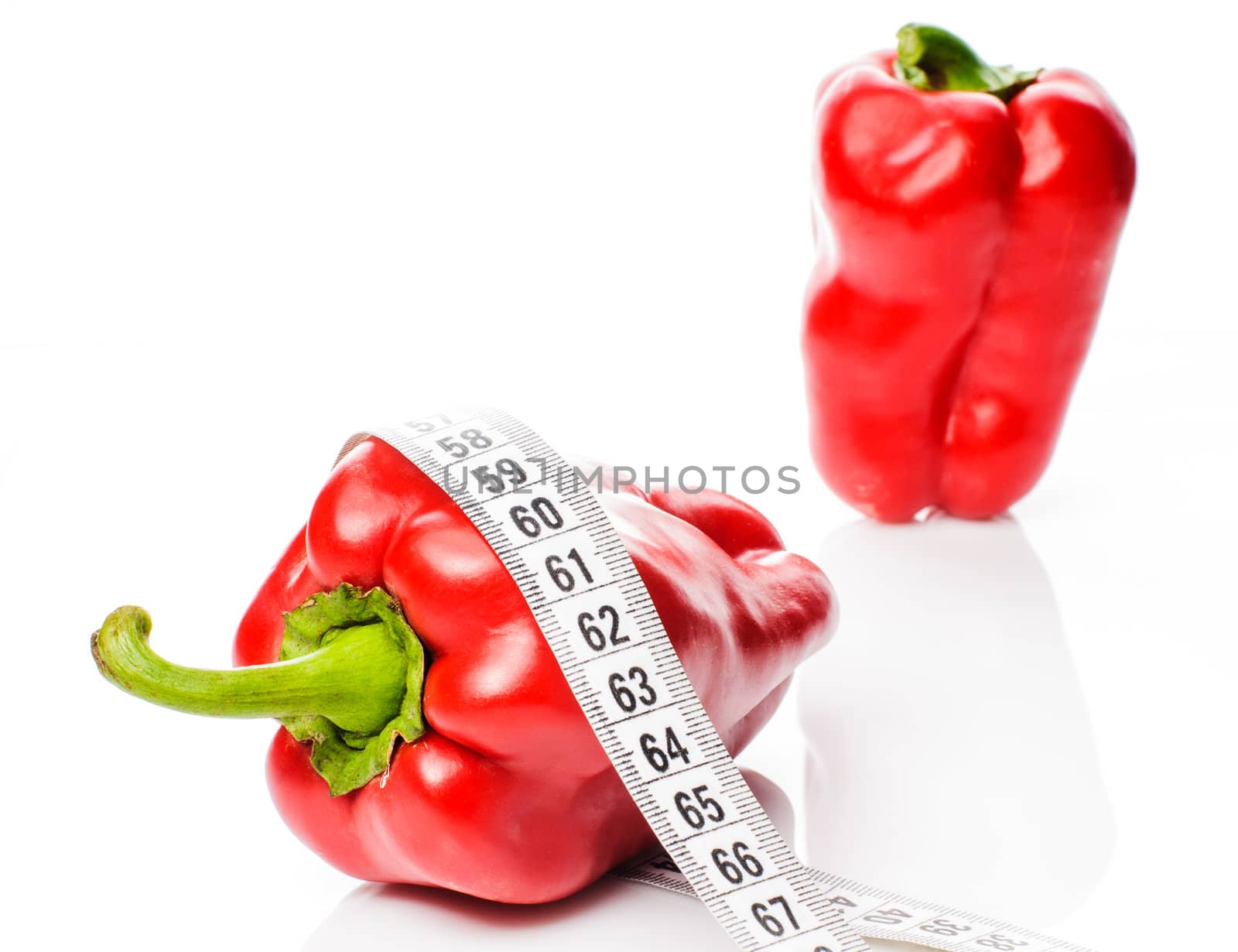Red sweet peppers in measure tape isolated on white background