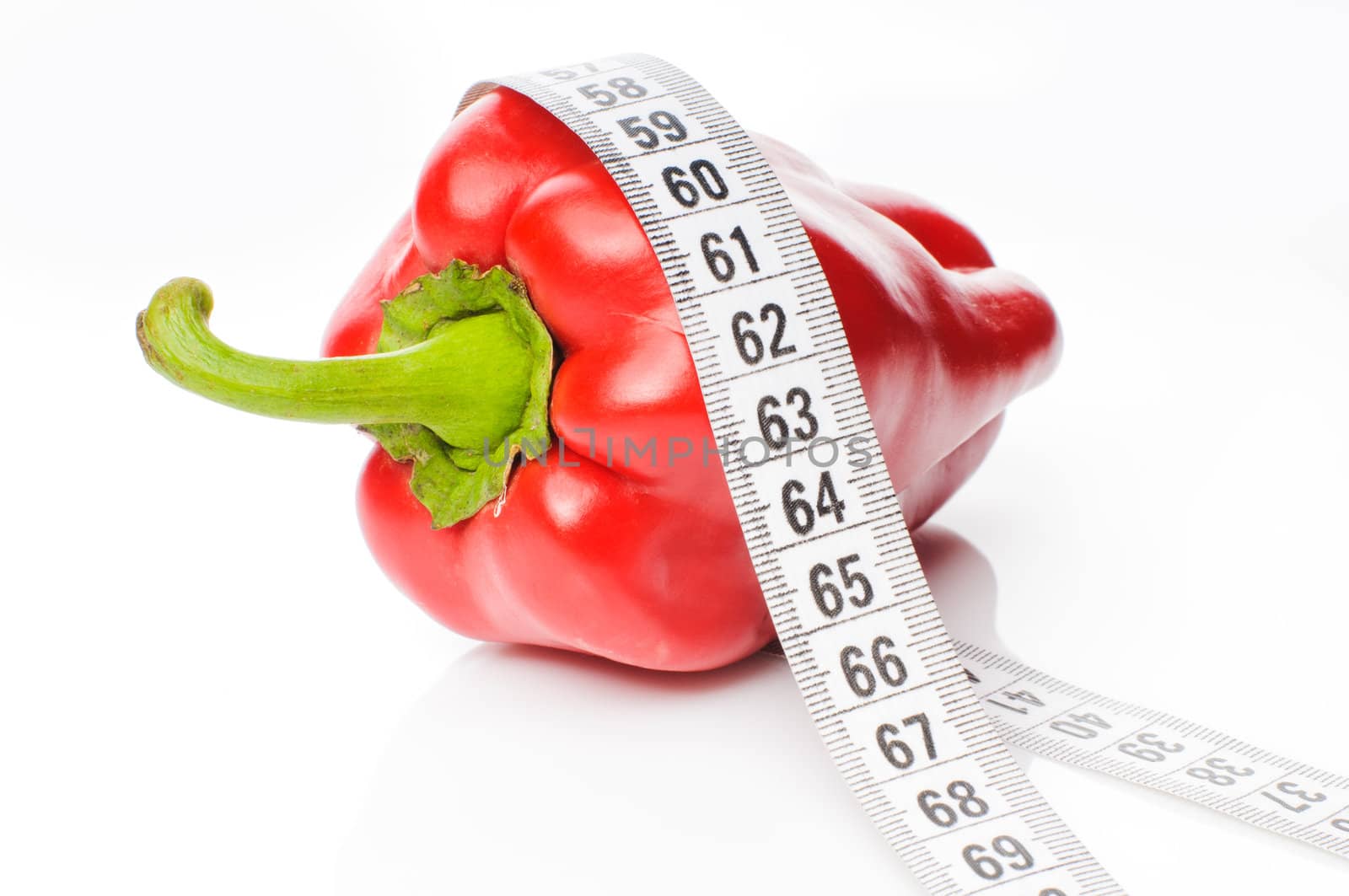 Red sweet pepper in measure tape isolated on white background