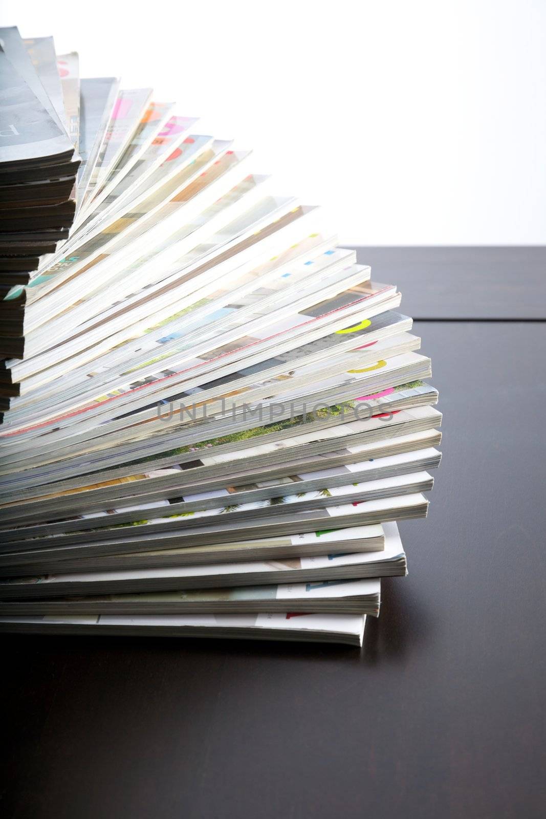 group of magazines piled on table and white background