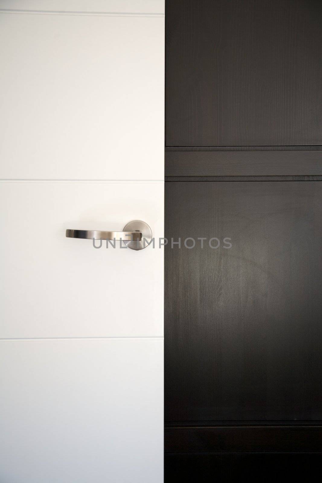 white modern door with handle on black wardrobe