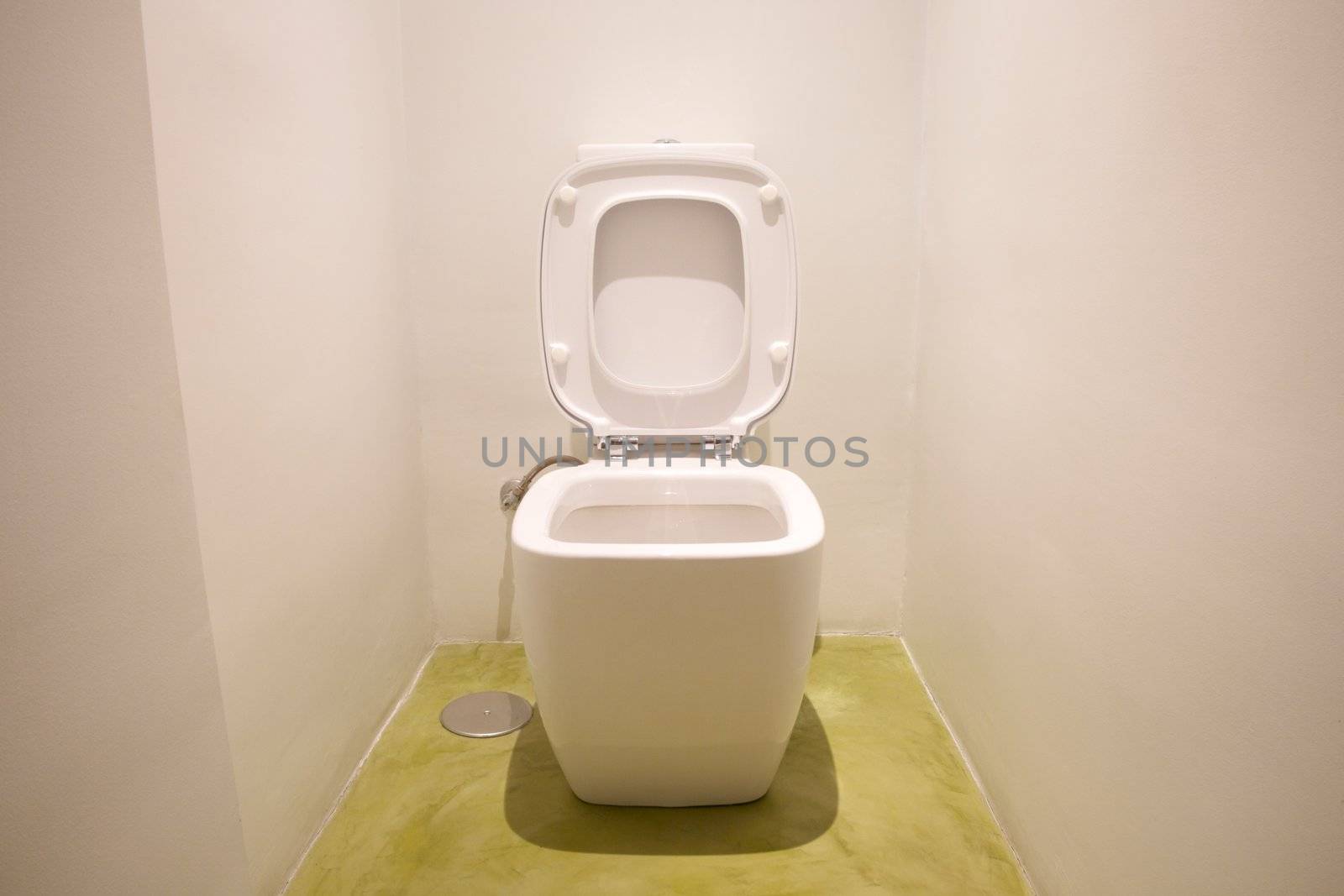 watercloset in white bathroom with green floor