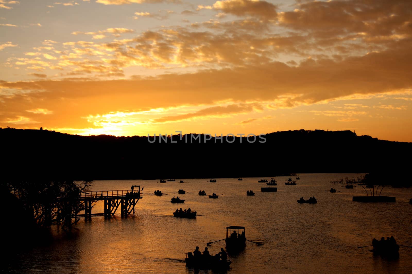 A beautiful view of silhouettes of  boats at a lake in India, at sunset.