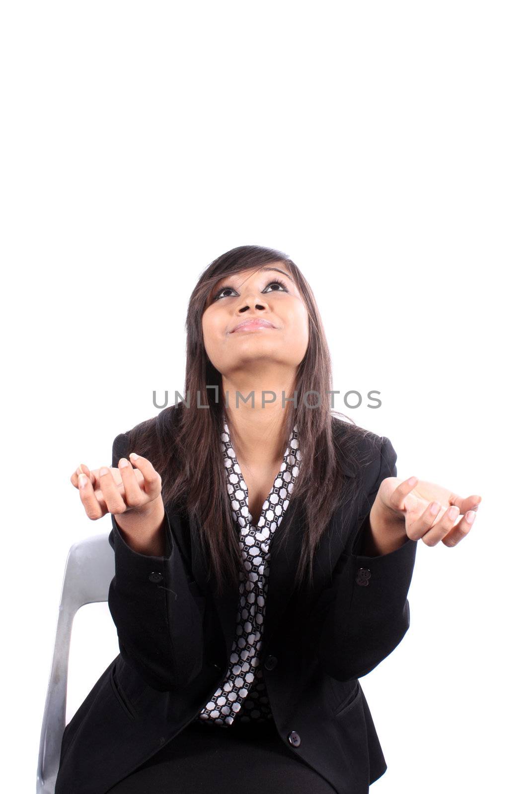 A metaphorical image of an Indian businesswomen praying for more success to god, on white studio background.