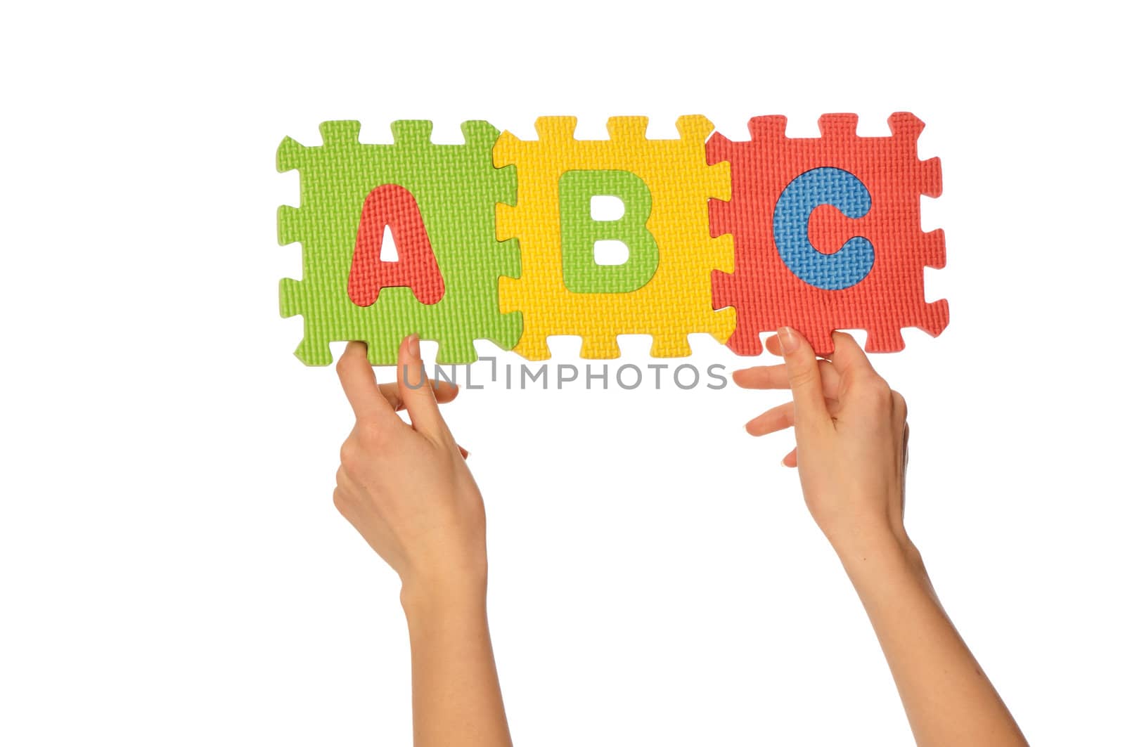 Teacher holding in the hand the amusing colored educational puzzles with alphabet