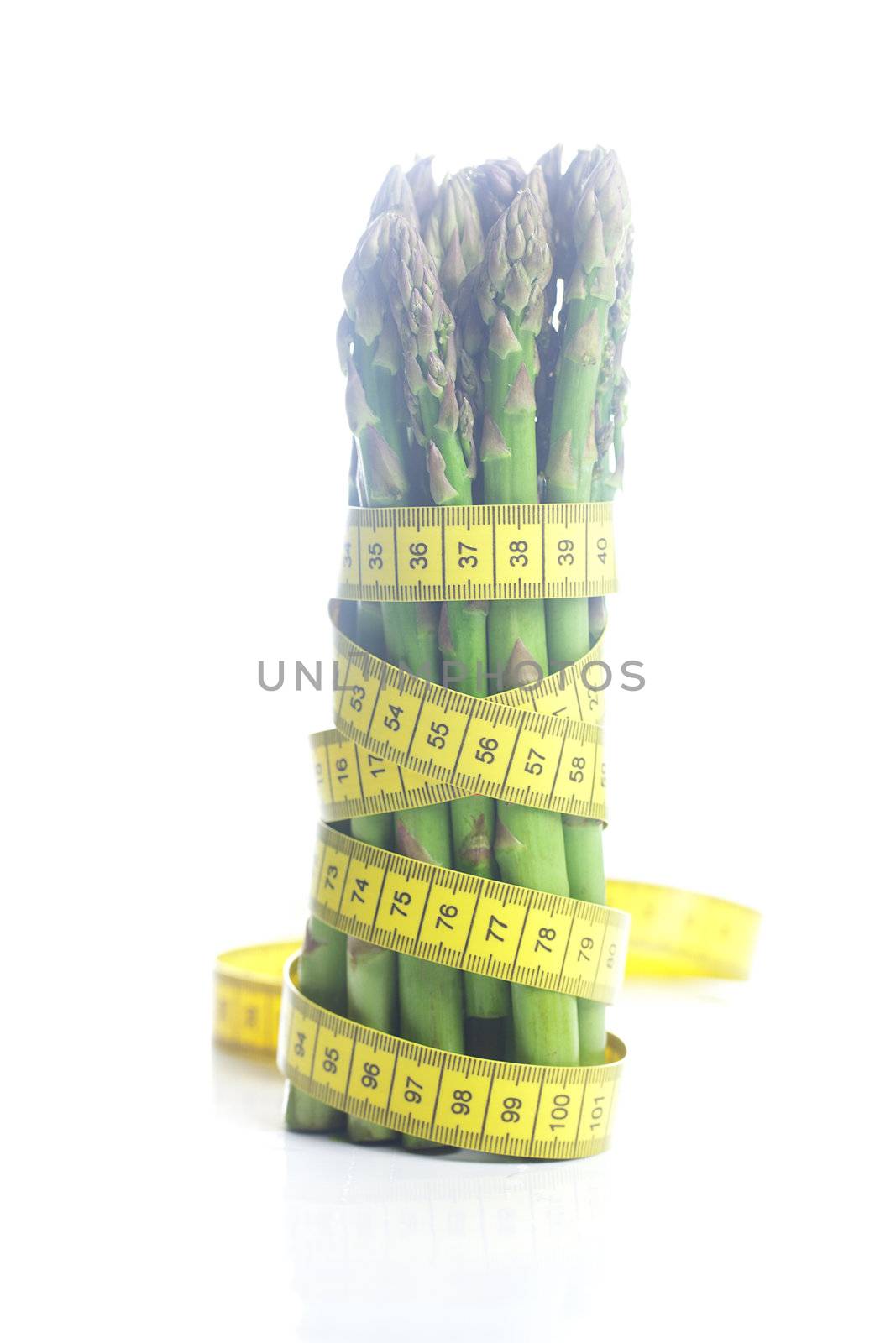 bunch of asparagus tied with measuring tape isolated on white