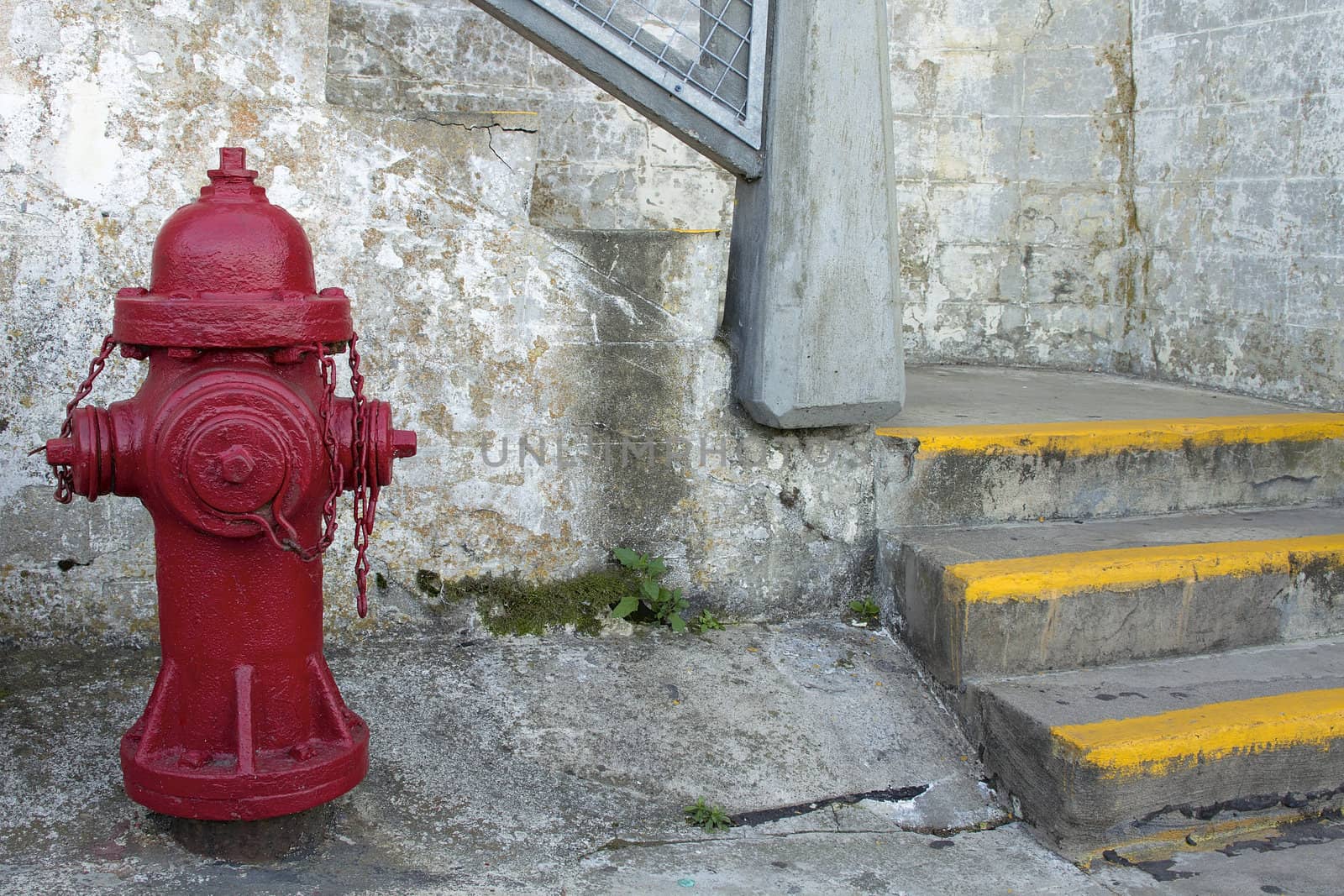 Red Fire Hydrant by the Staircase with Grunge Textured Wall Background