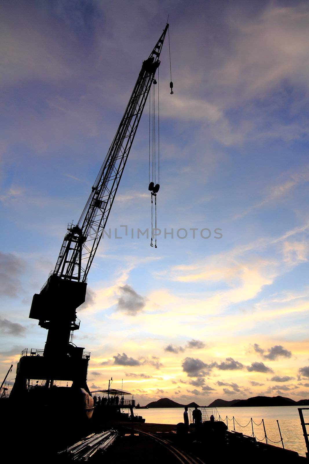 Cranes in dockside at sunset by rufous