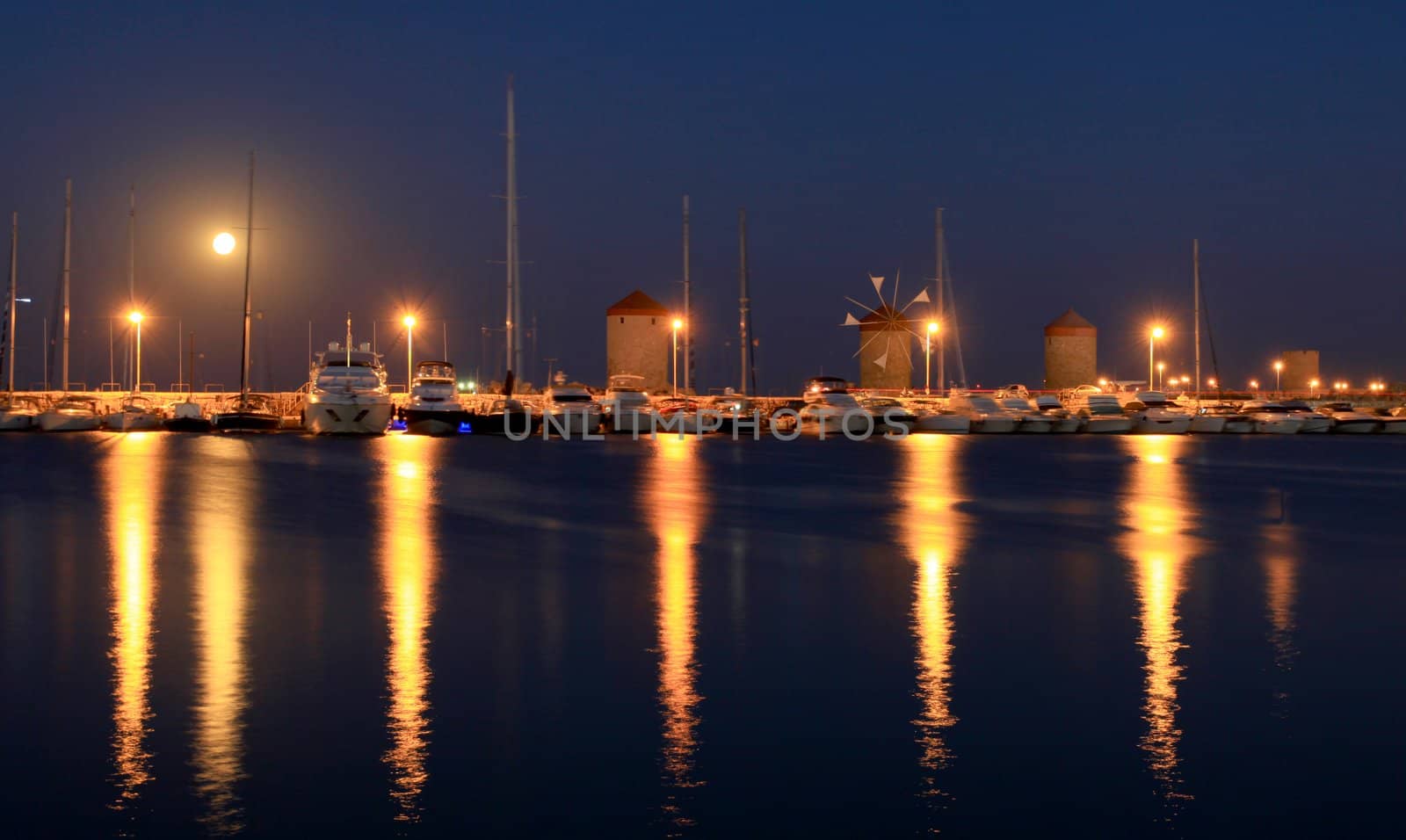 Rhodes harbor and windmills in Greece at sunset by olliemt