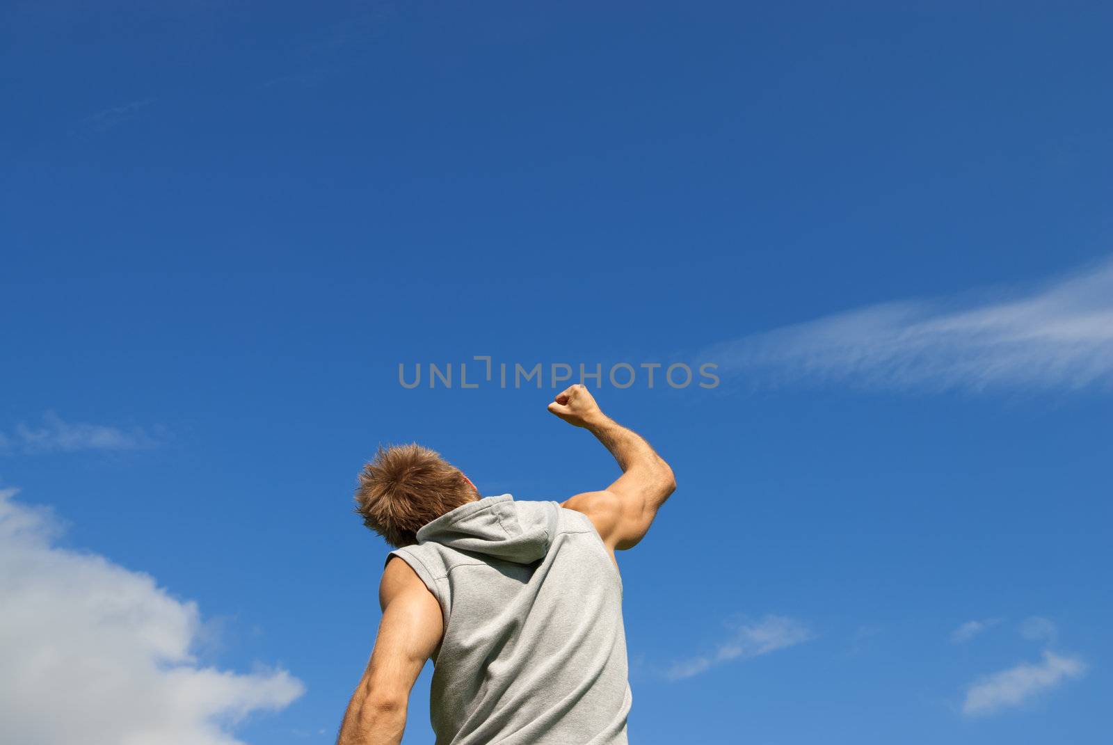 Sporty young man with his arm raised in joy by anikasalsera