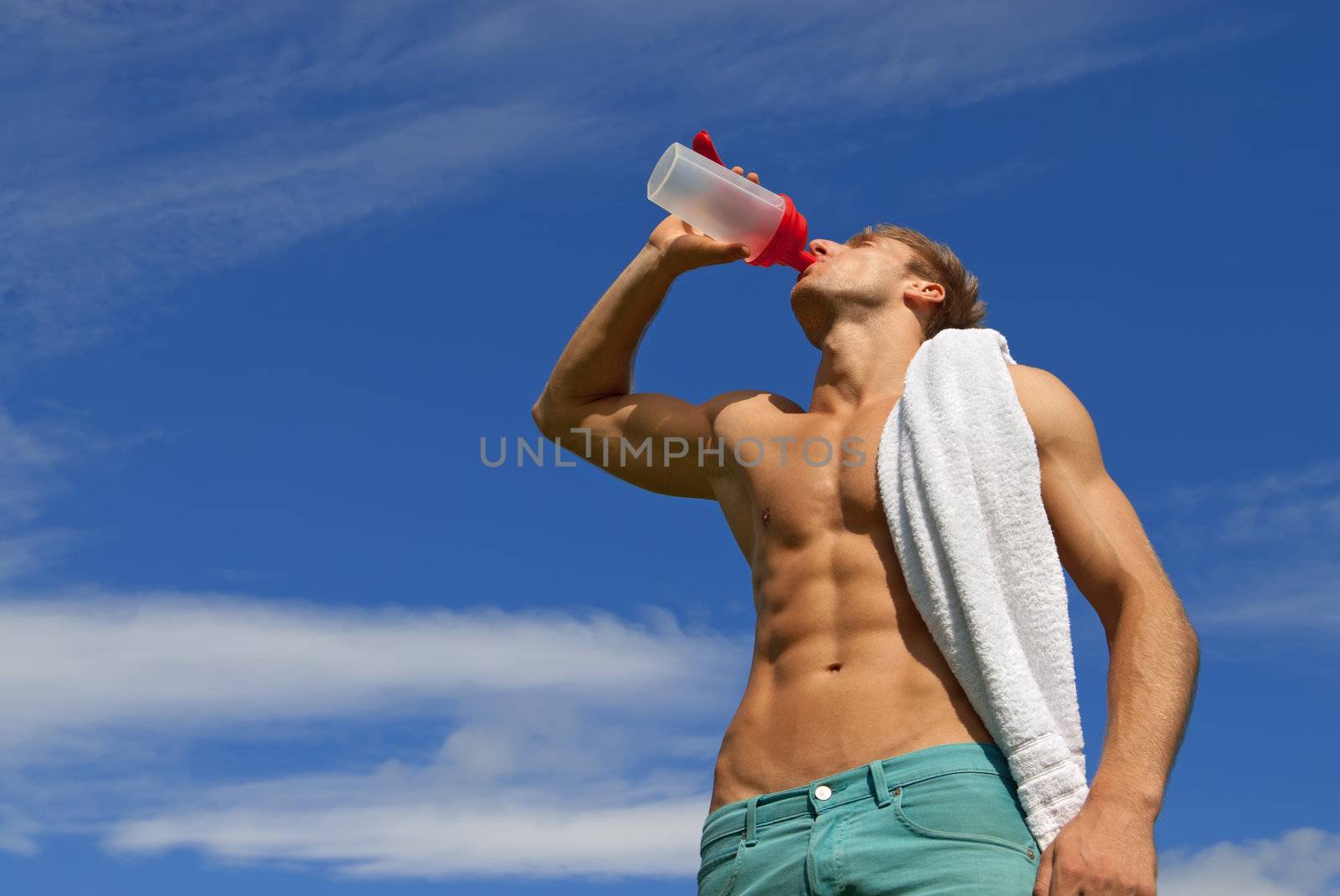 Fit young man drinking water by anikasalsera
