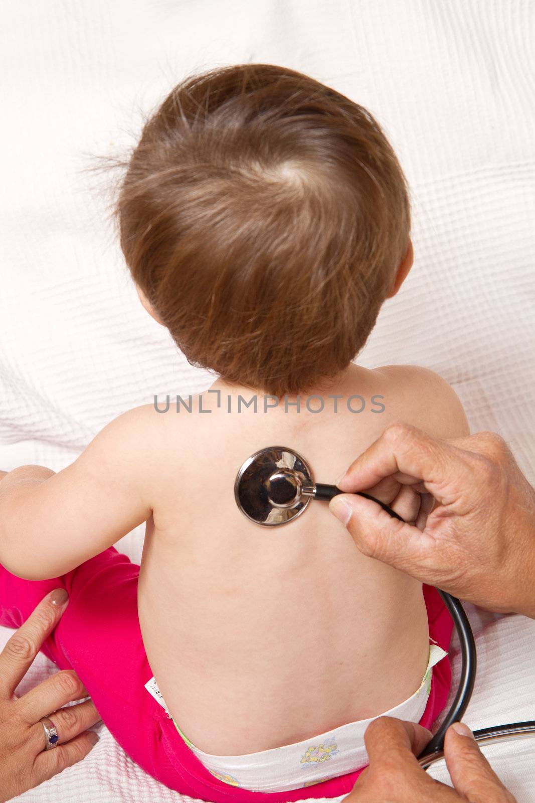 Children's doctor exams infant with stethoscope 