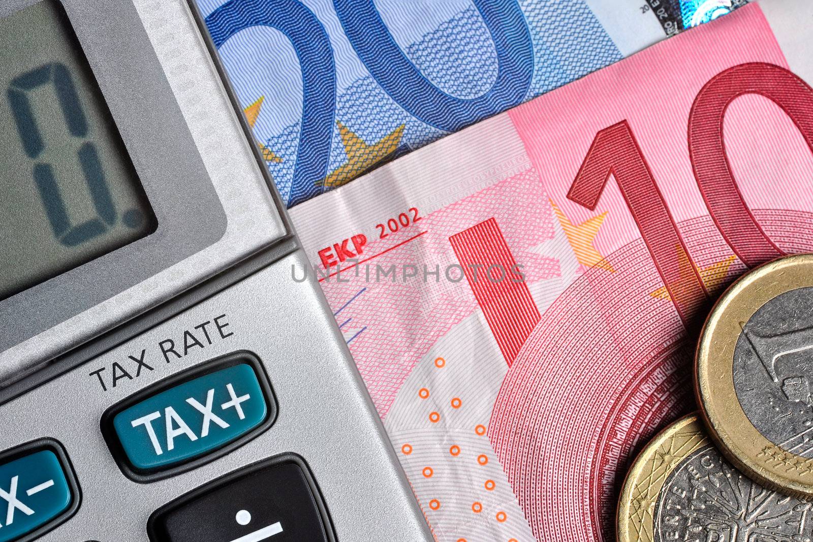 Detail of calculator, focusing the TAX key, next to some Euro bills and coins