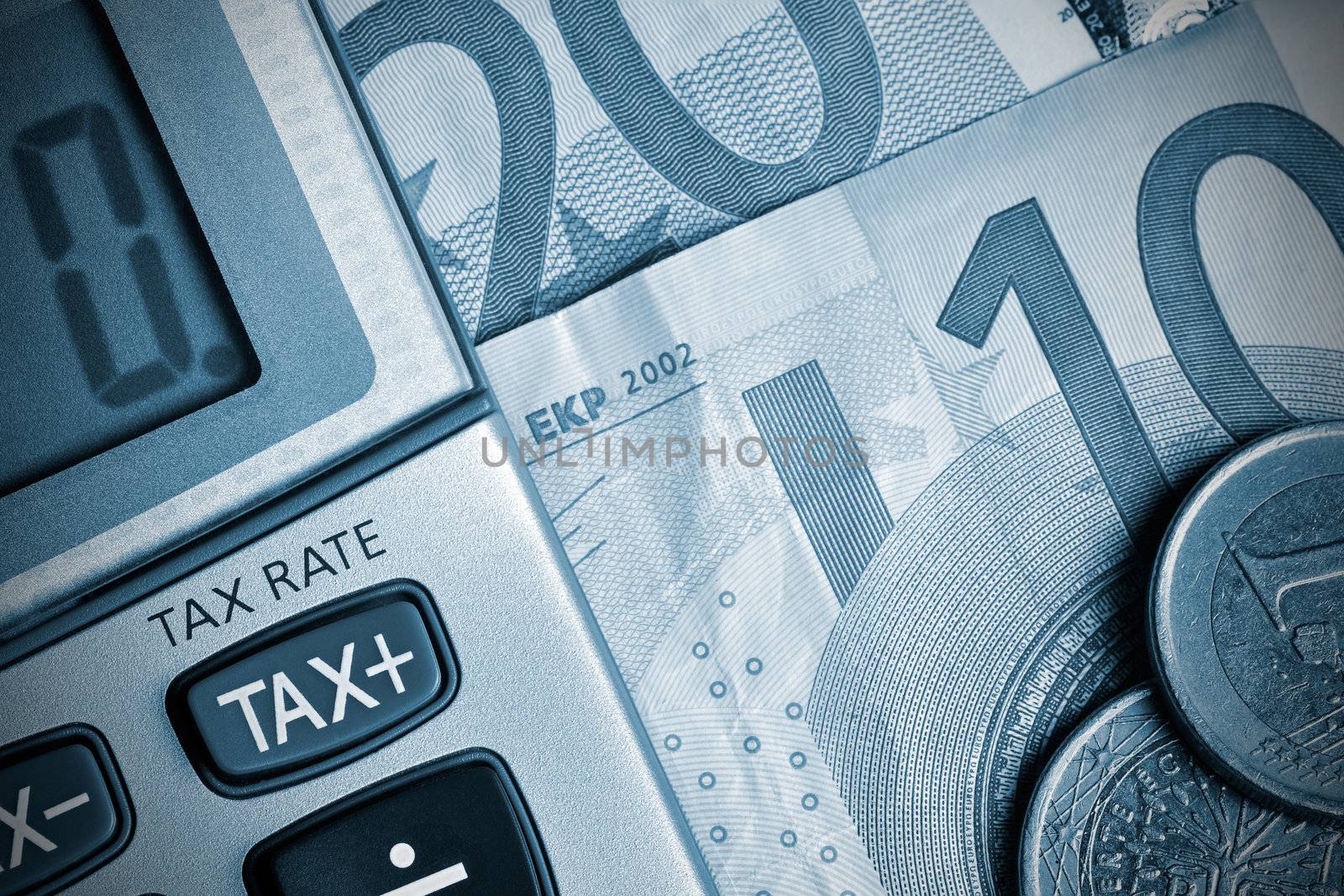 Detail of calculator, focusing the TAX key, next to some Euro bills and coins