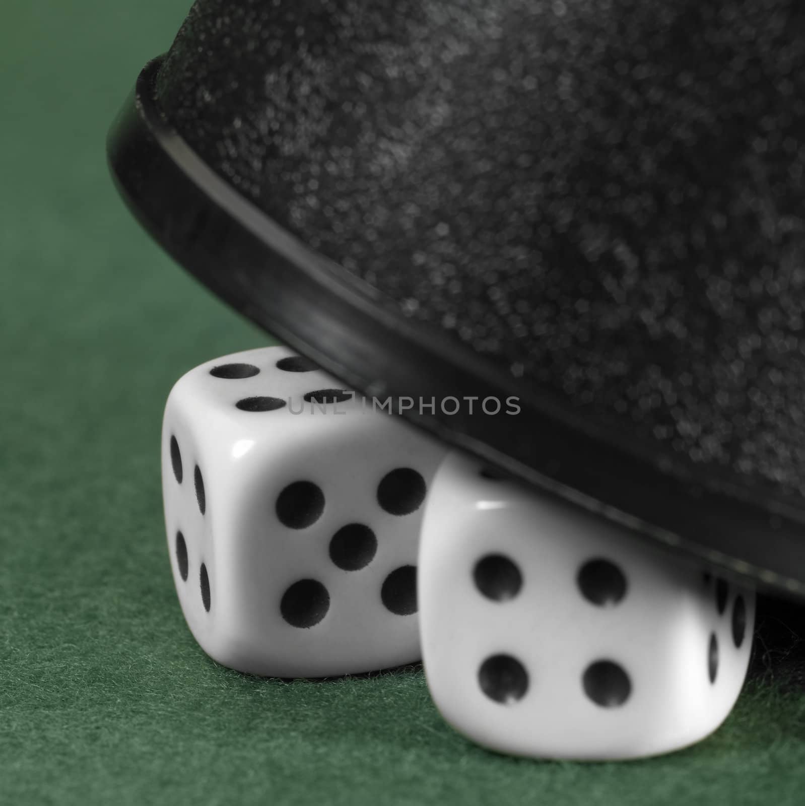 2 half hidden dice and cup closeup on green felt