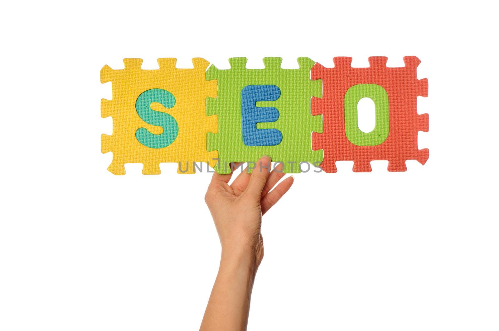 teacher holding in the hand the amusing colored puzzles with word SEO