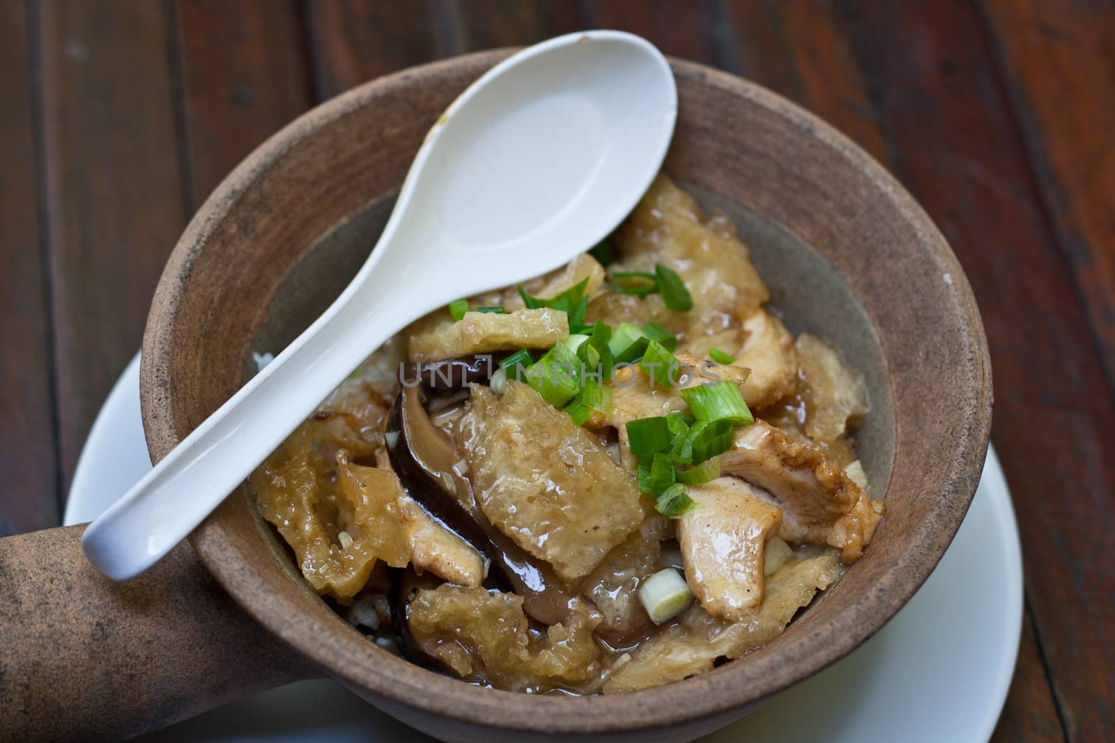 Fried fish maw topped on rice in bowl.