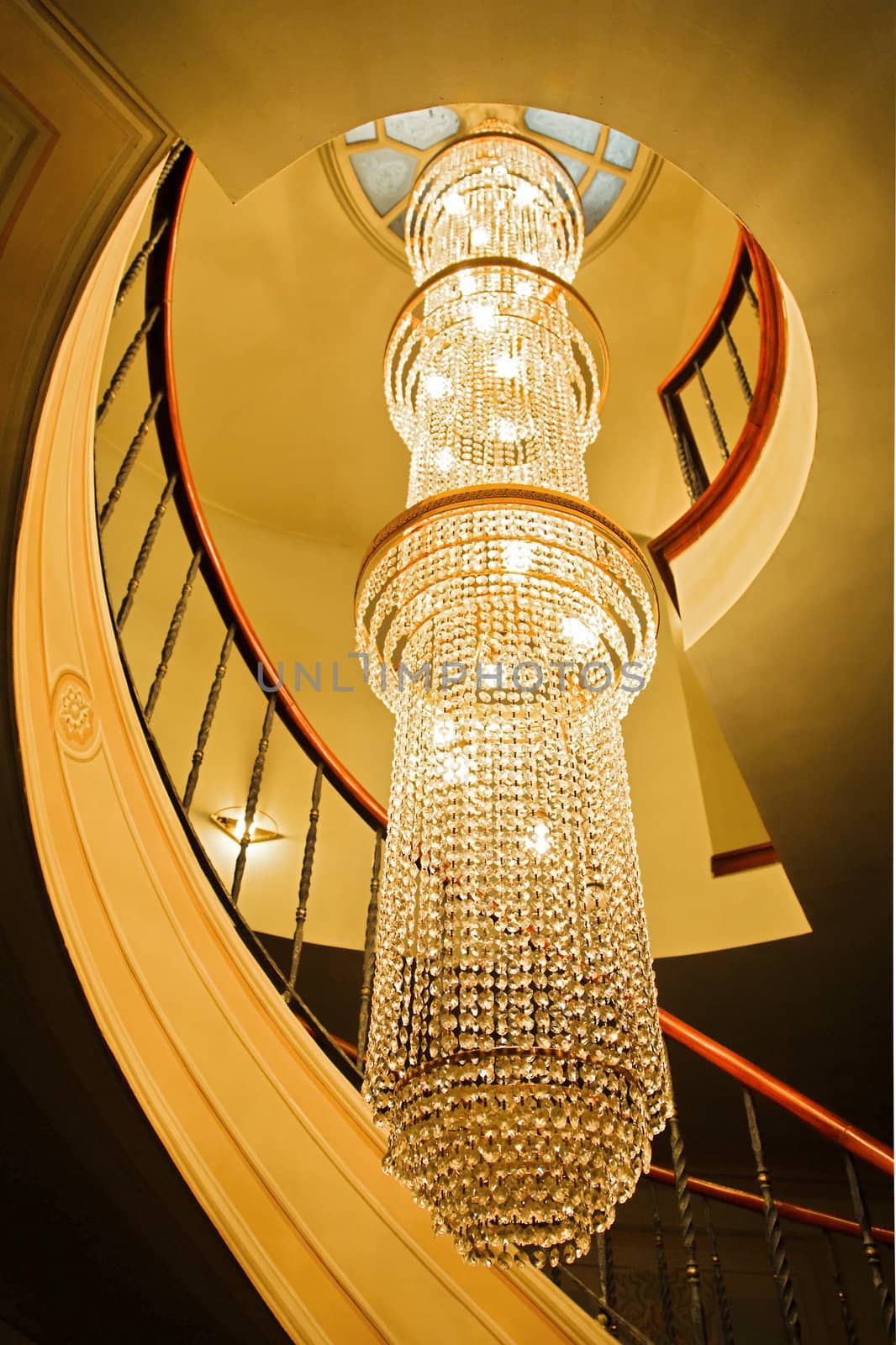 Generic portrait of a long crystal chandelier lighting up a stairwell of a spiral staircase. Location of this shot was Istanbul, Turkey