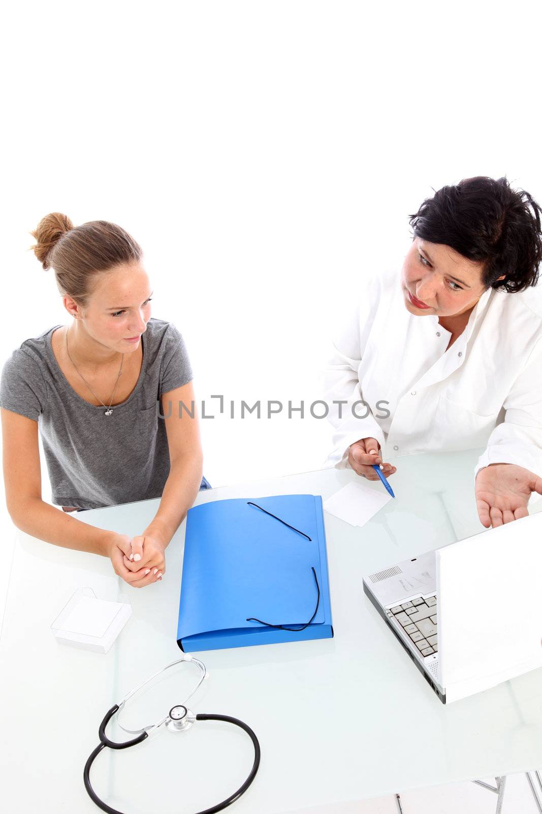 High angle view of a female doctor and young teenaged patient in consultation with the doctor explaining something in detail with the help of her laptop computer High angle view of a female doctor and patient in consultation with the doctor explaining something in detail with the help of her laptop computer 
