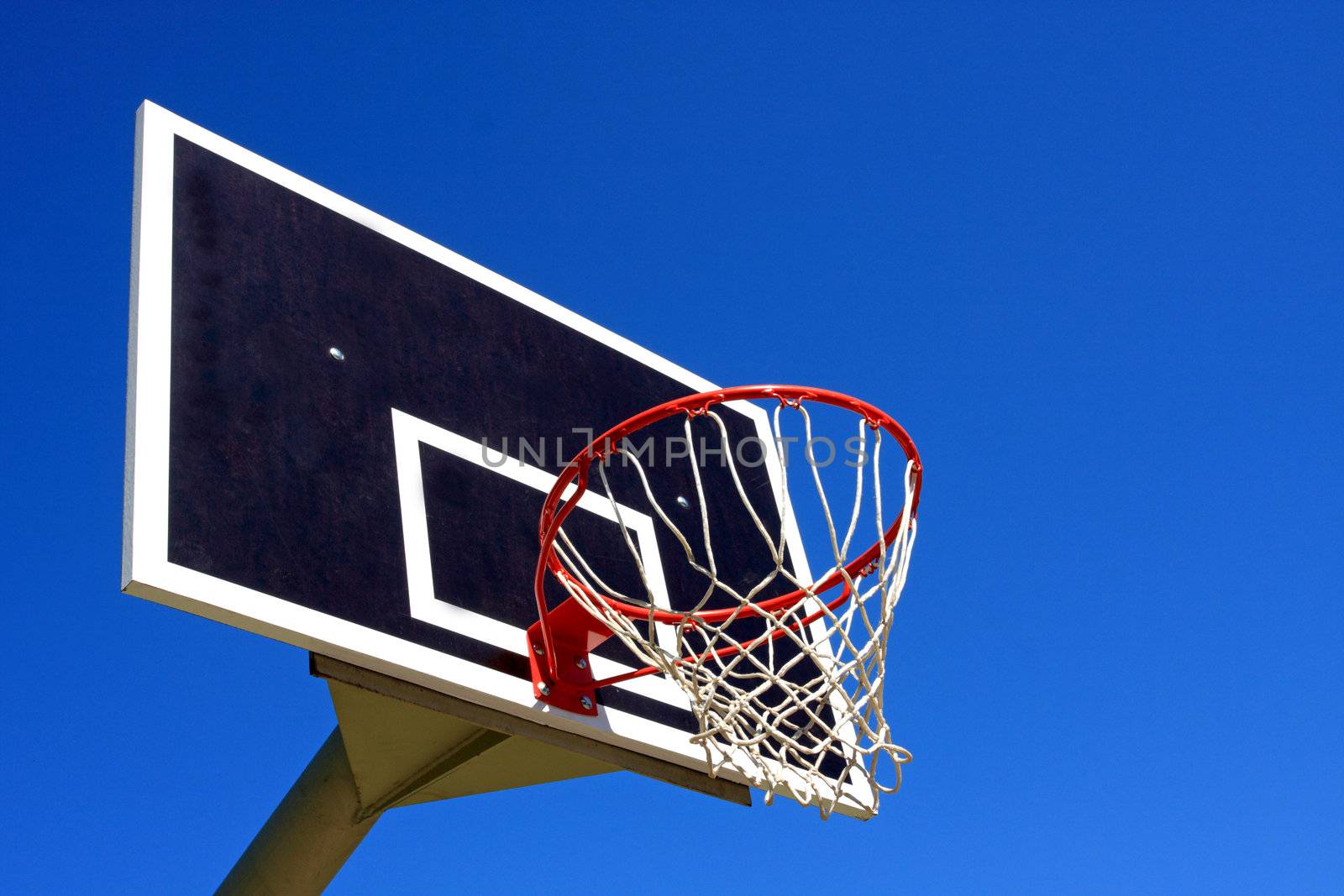 Basketball hoop against bright blue sky