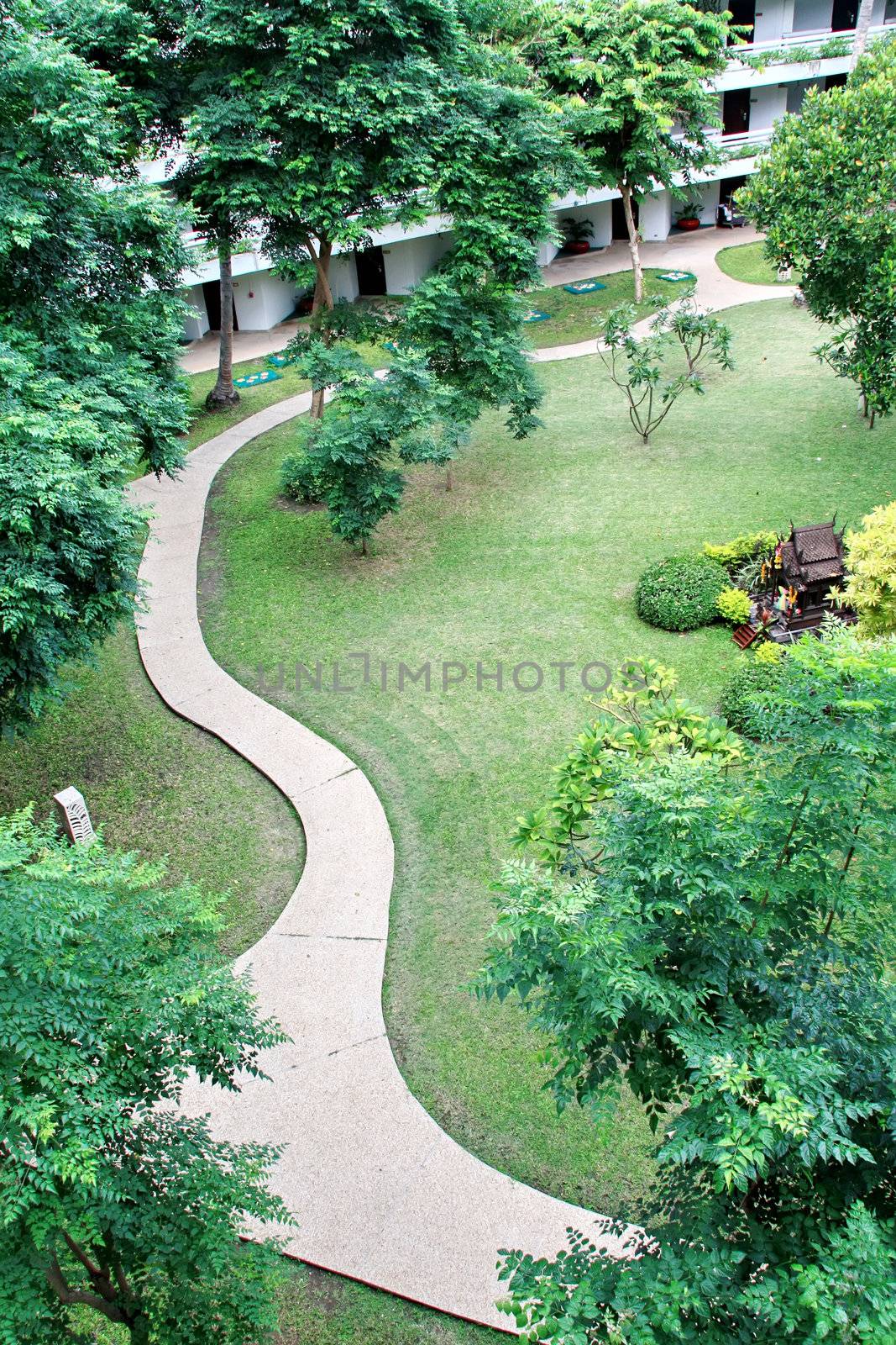 The curvy walk way of a city park by phanlop88