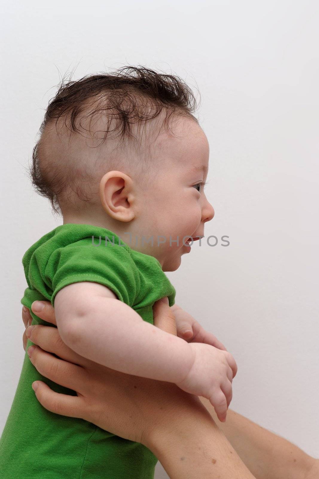 Cute smiling baby held by his mother profile view by slavapolo