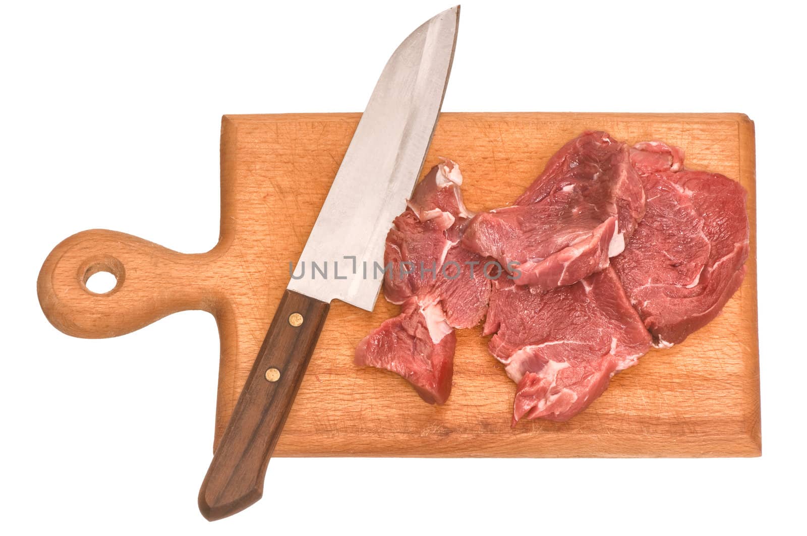 Slices of the meat on the board with knife on the kitchen