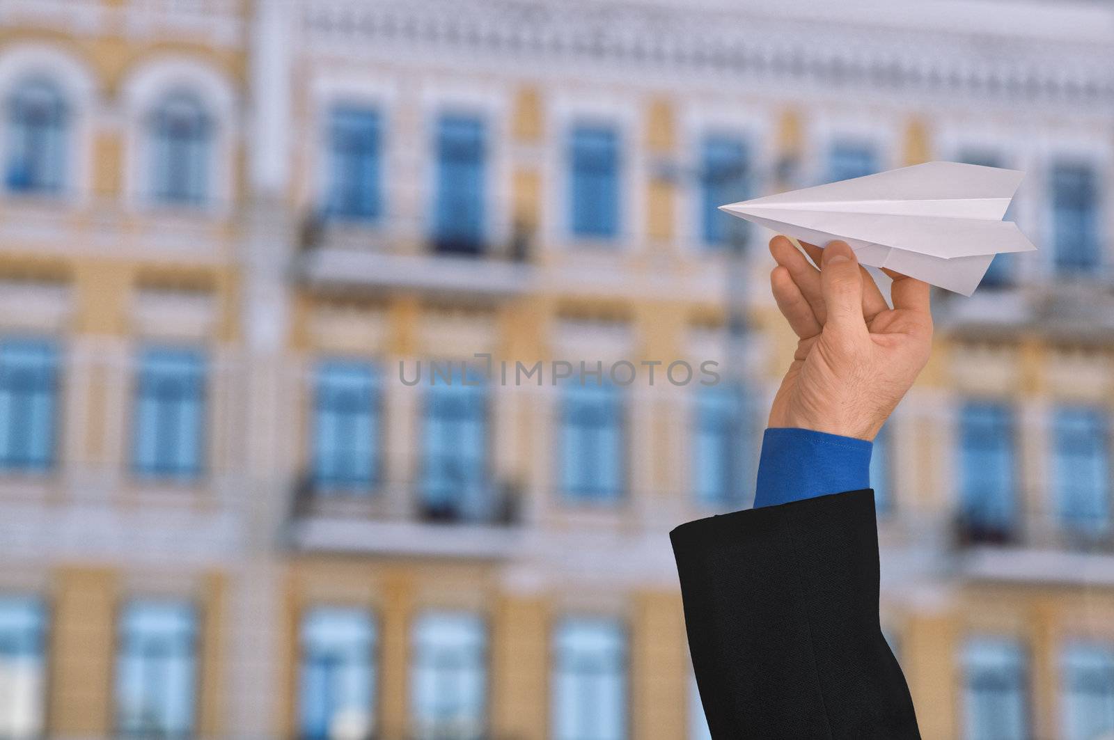 businessman in a business suit throwing white paper plane