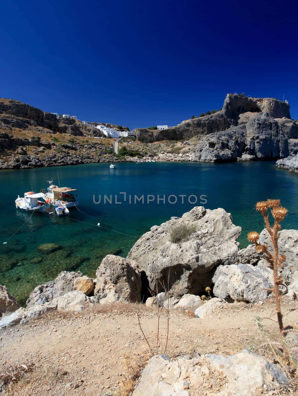 Beautiful St Pauls Bay shadowed by the temple and castle ruins at Lindos 