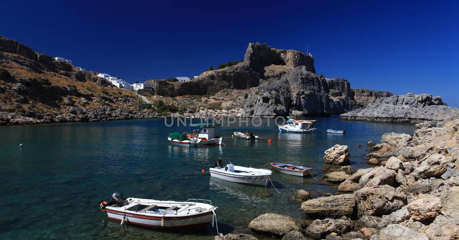 Beautiful St Pauls Bay shadowed by the temple and castle ruins at Lindos 