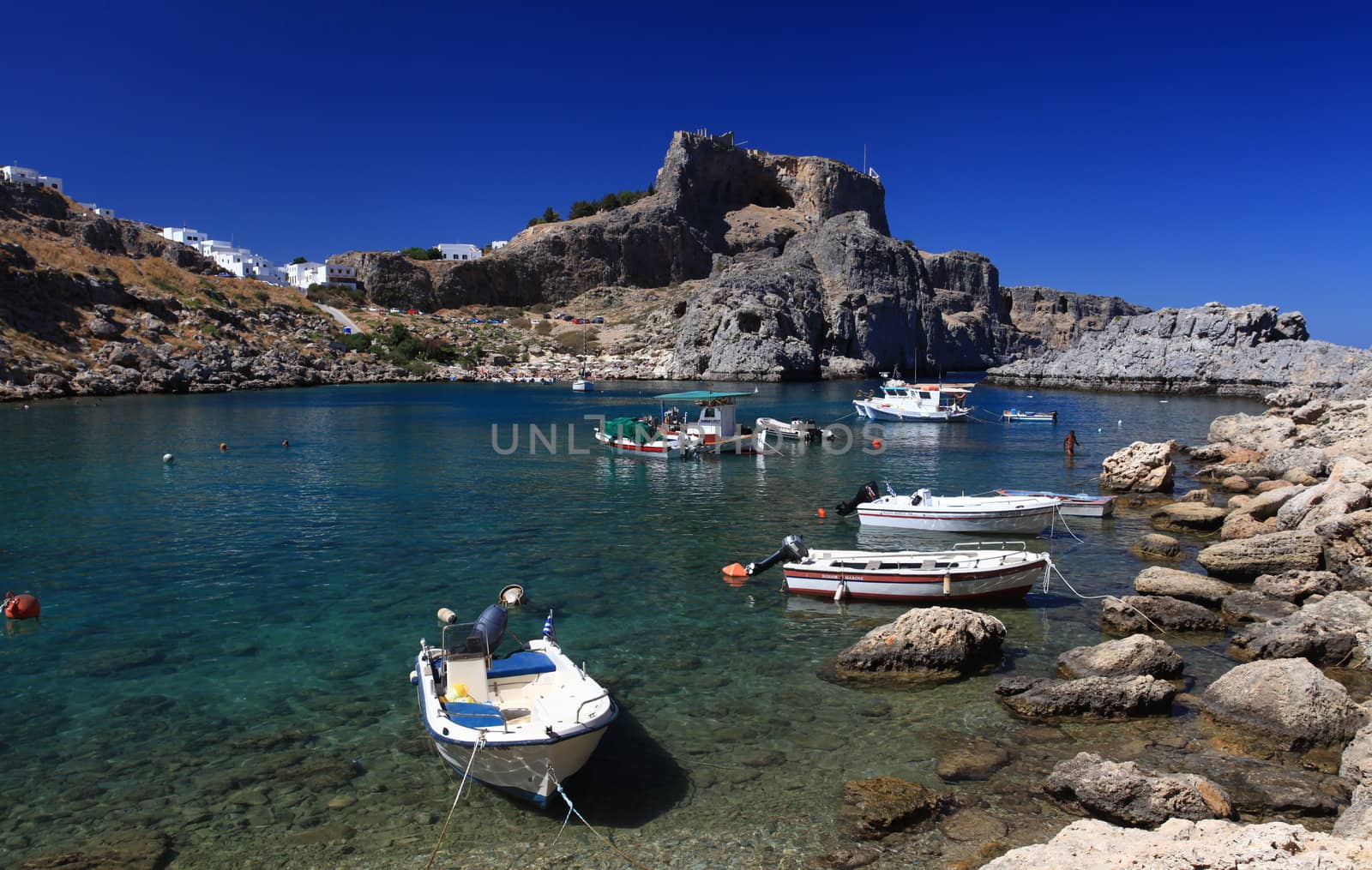 Beautiful St Pauls Bay shadowed by the temple and castle ruins at Lindos 